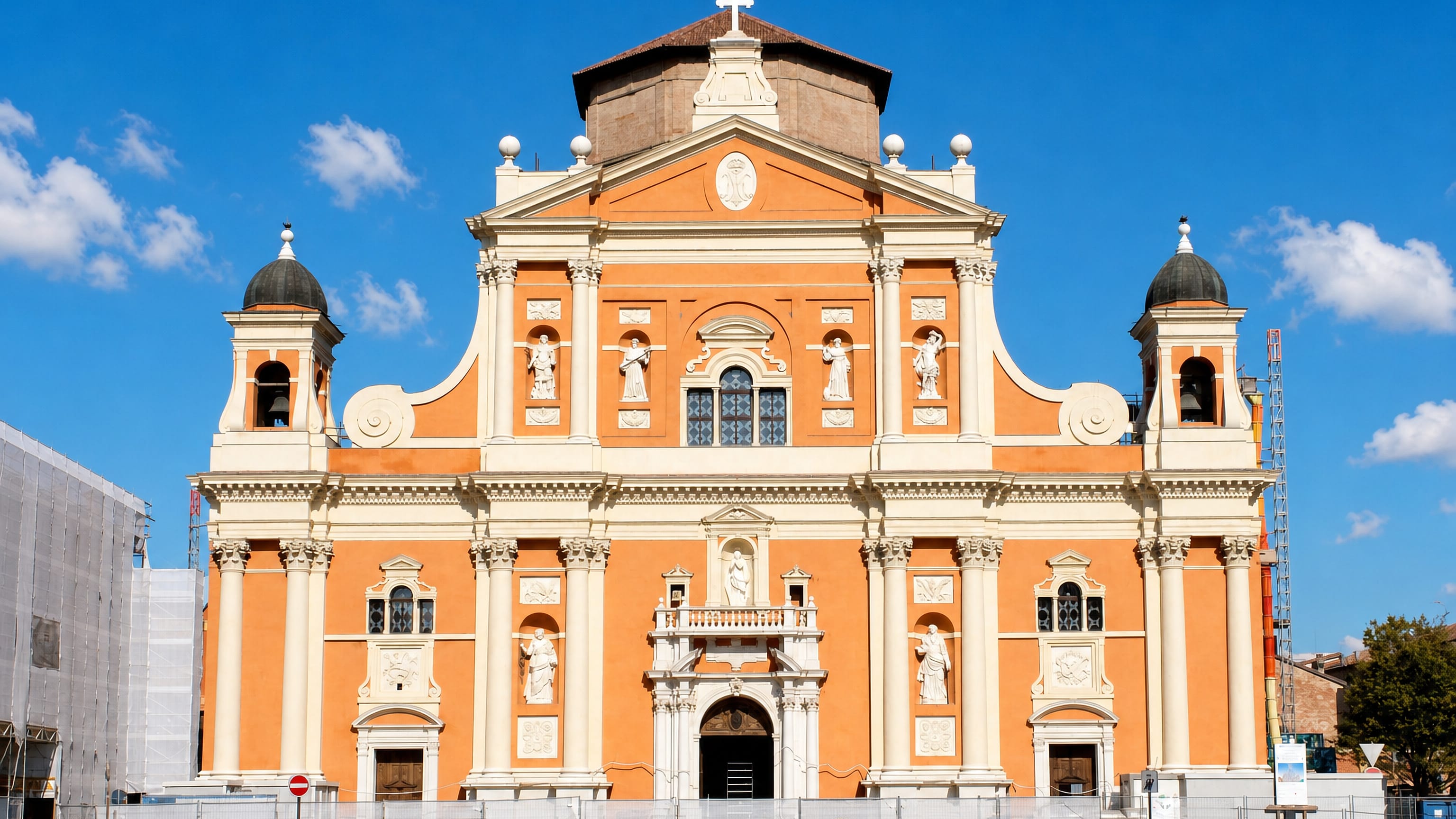 Orange and white Baroque church facade above the main square of Carpi, Emilia-Romagna, Italy.
