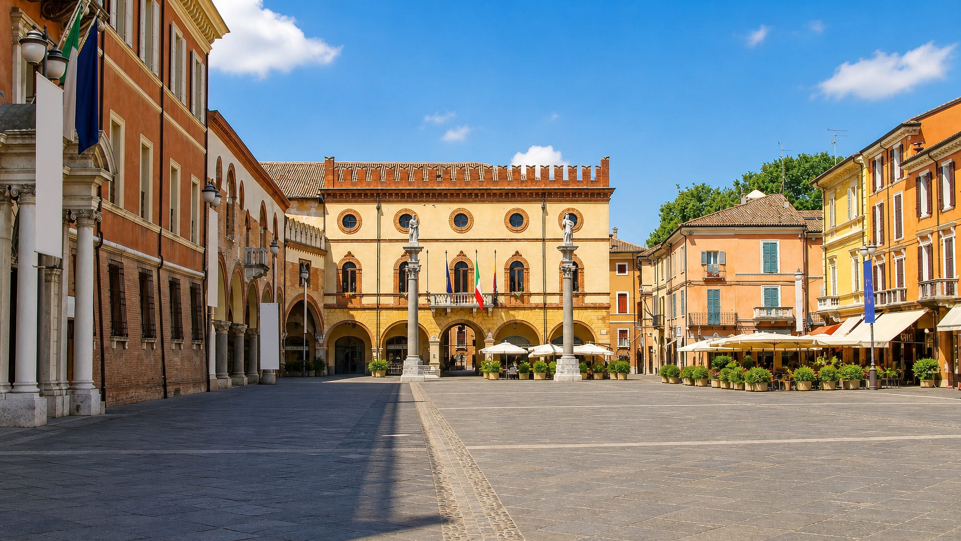 Piazza del Popolo in Ravenna, Italy, with its two Venetian columns, arcaded Palazzo Veneziano and cafe umbrellas.