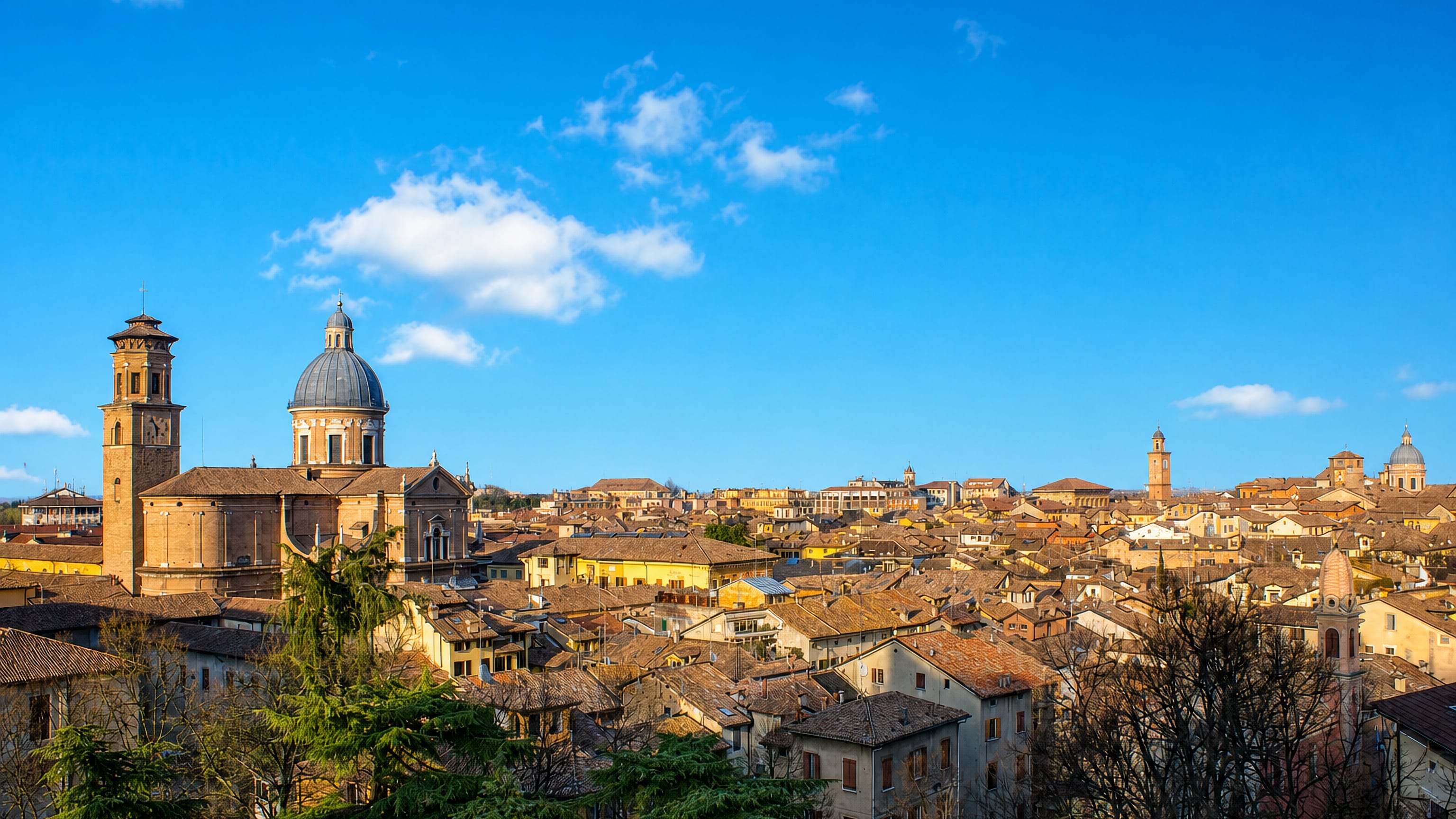 Domed Basilica della Ghiara and its bell tower above the terracotta rooftops of Reggio nell'Emilia.