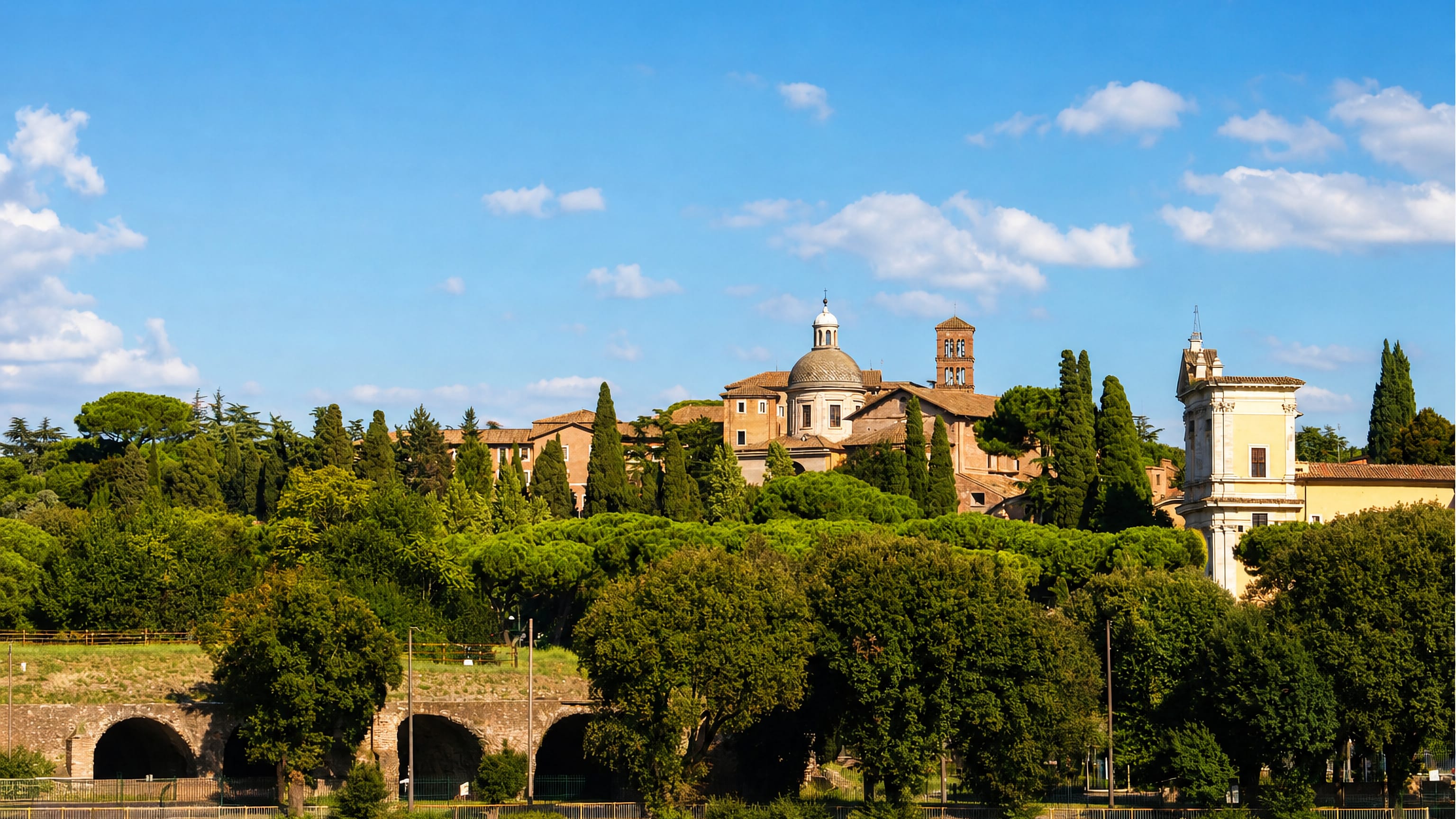 Domes, a Romanesque campanile and cypresses on Rome's green Celio hill above the Tiber