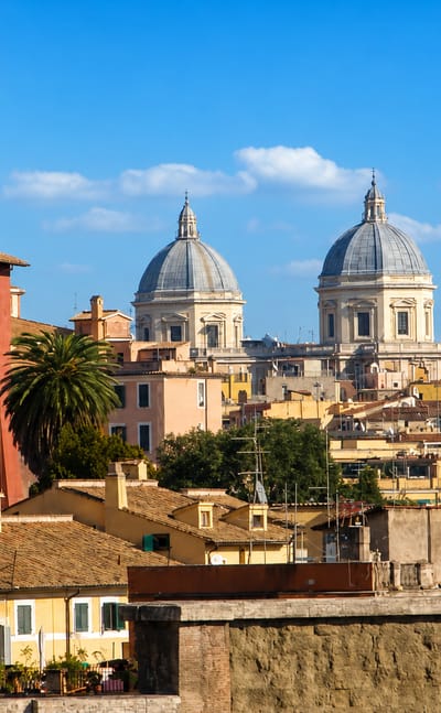 Monti rooftops in Rome with the campanile and twin domes of Santa Maria Maggiore against a blue sky