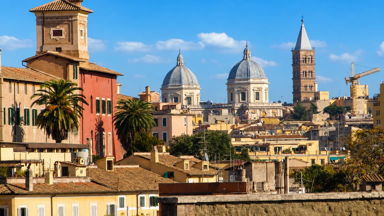Monti rooftops in Rome with the campanile and twin domes of Santa Maria Maggiore against a blue sky