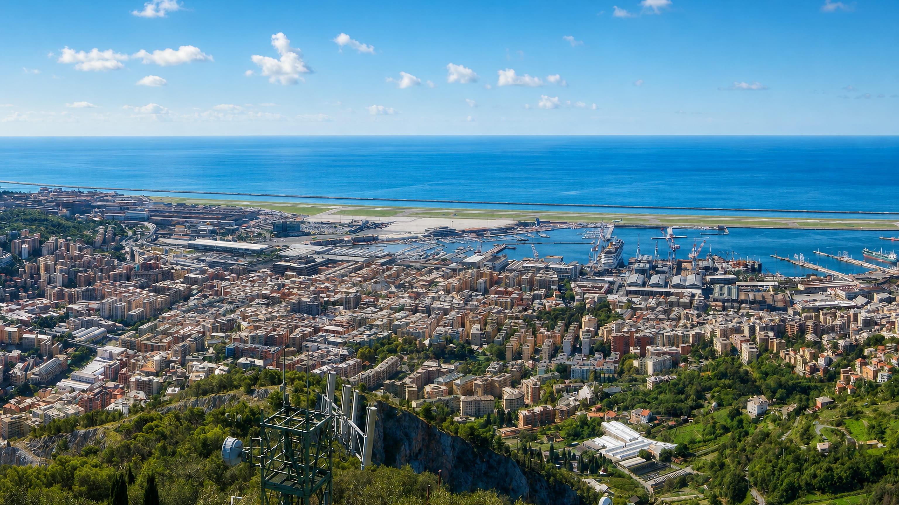 Hillside view over Sestri Ponente, Genoa, with the airport runway, shipyards and harbour on the Ligurian Sea.