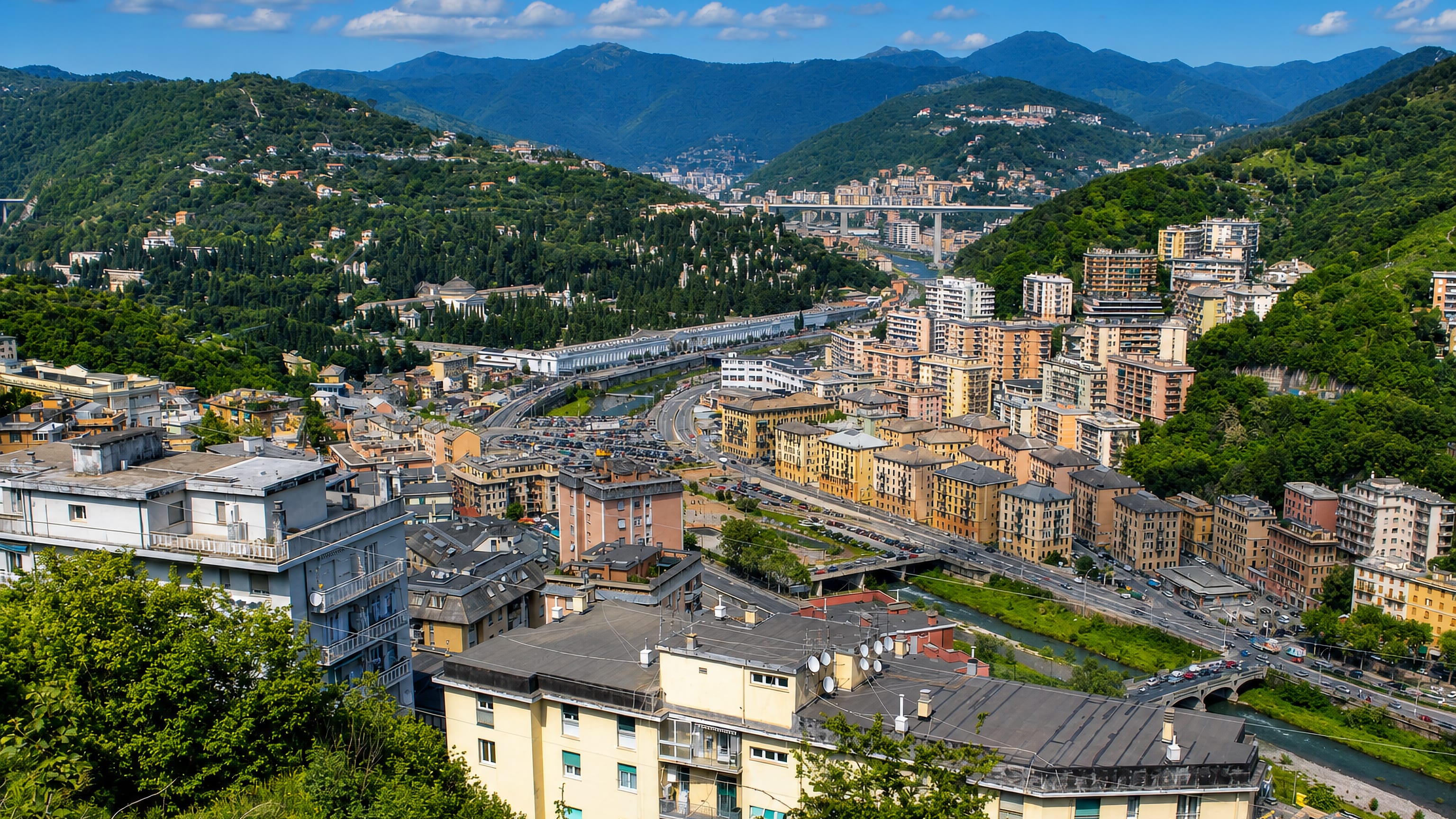 Staglieno in Genoa's Bisagno valley, pastel apartment blocks and bridges between wooded Ligurian hills.