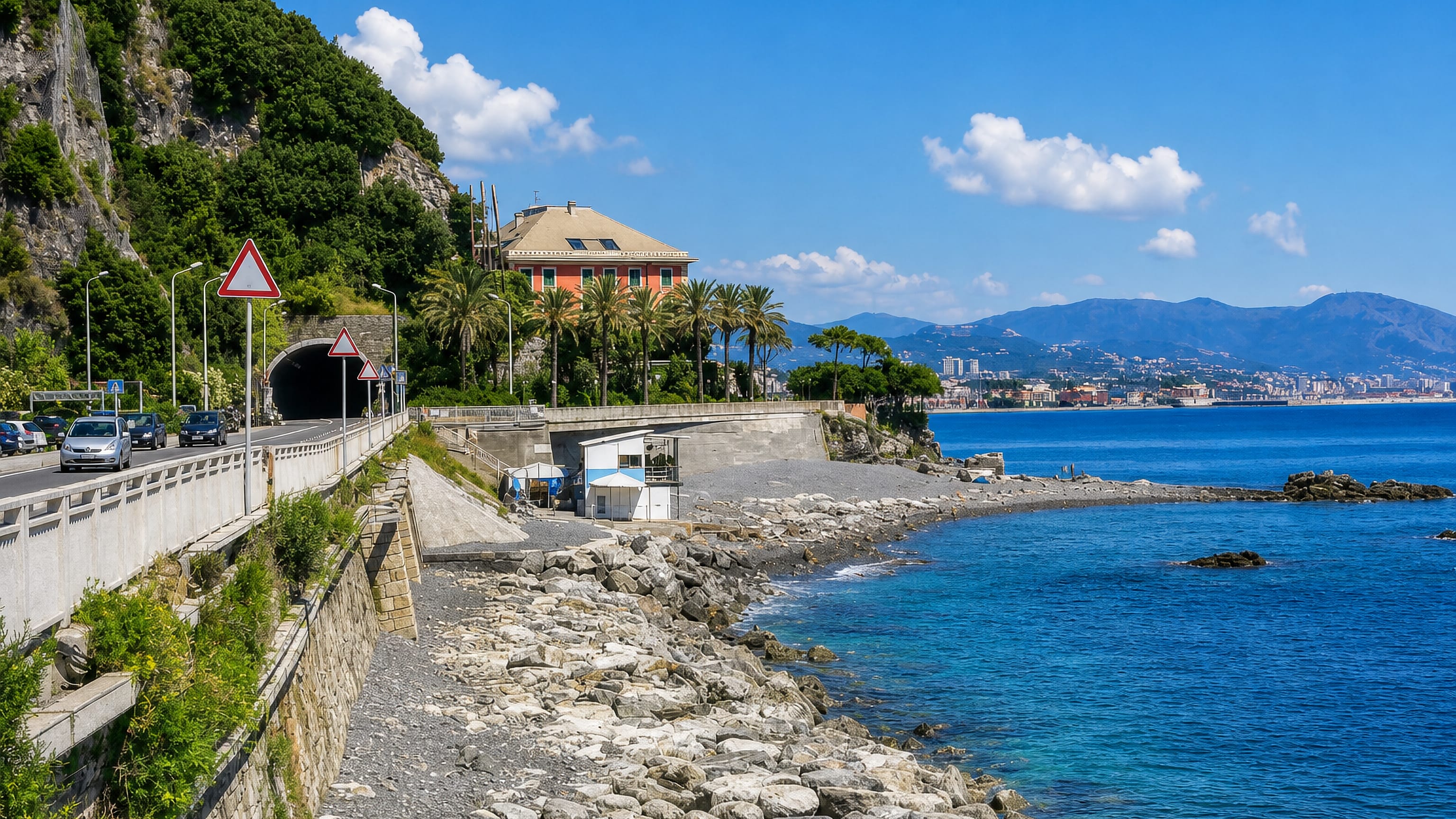 Coastal road and tunnel above the rocky shore at Vesima, with palms and the Genoa coastline beyond