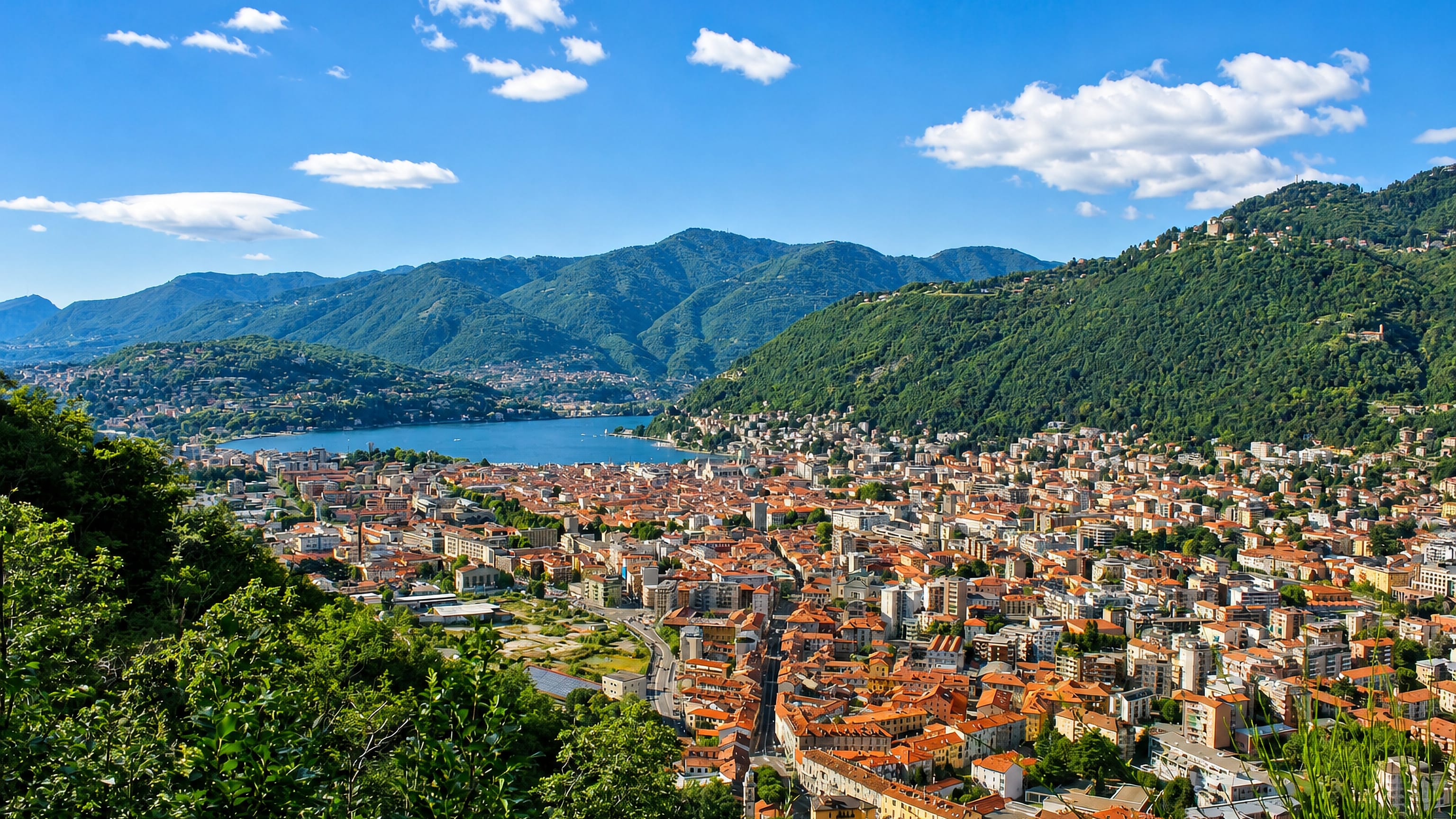Como from the Brunate hillside, terracotta rooftops packed at the head of Lake Como below Alpine ridges.