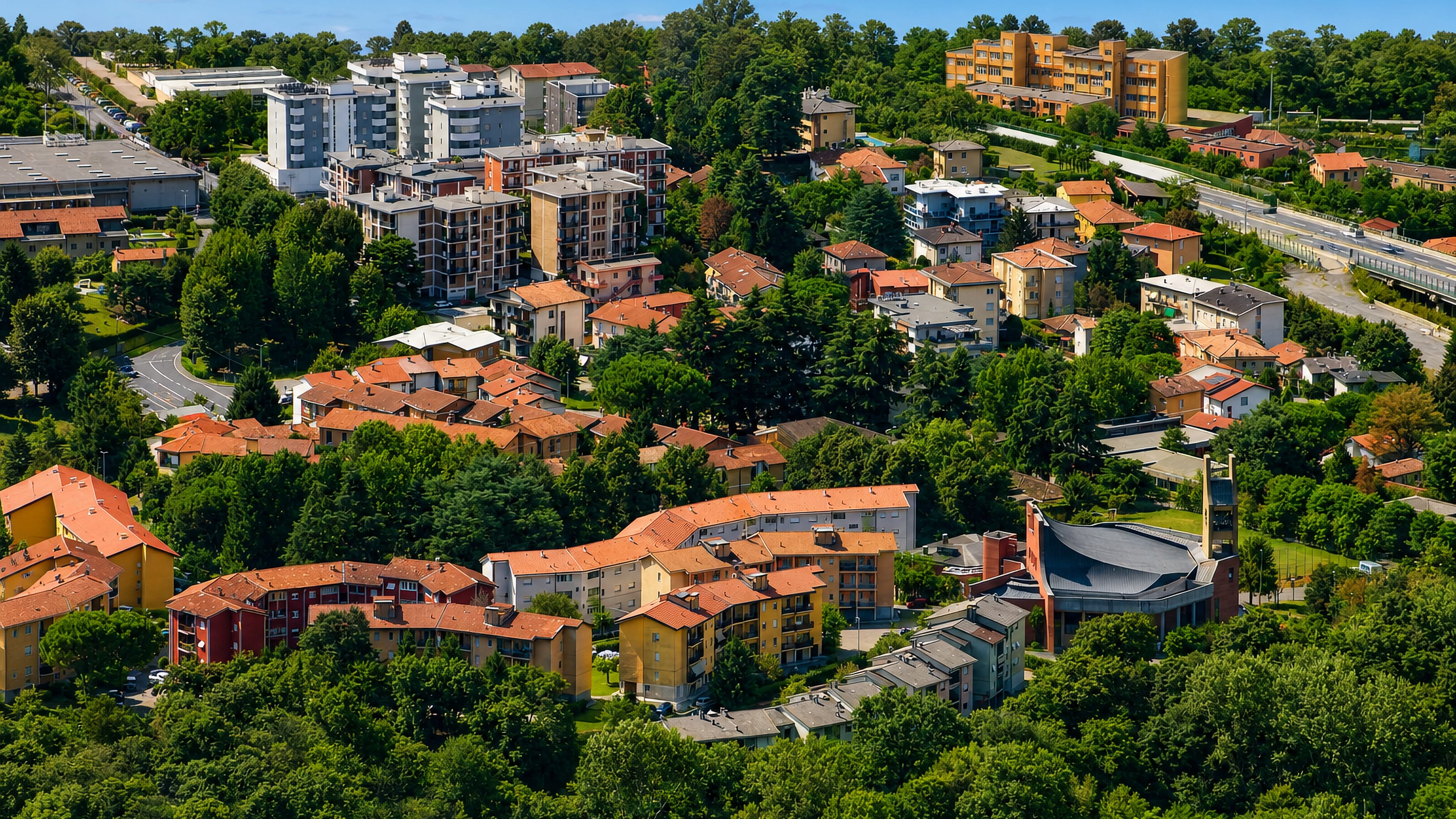 Terracotta roofs, apartment blocks and a modern church tower among wooded hills in Sagnino, Como.