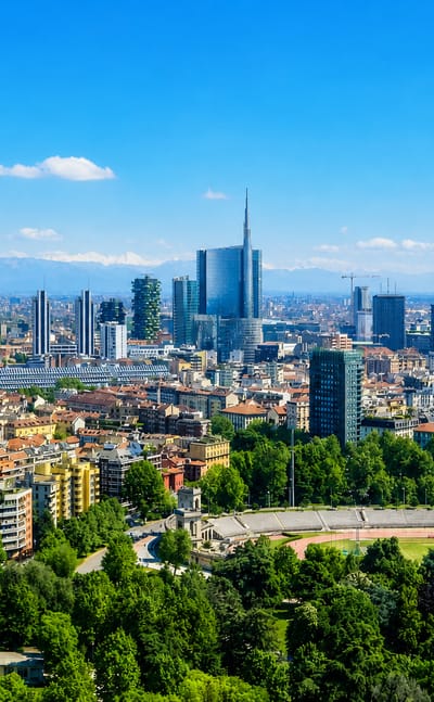 Milan's Porta Nuova skyline with the UniCredit Tower and Bosco Verticale, snow-capped Alps beyond and the Arena Civica below.