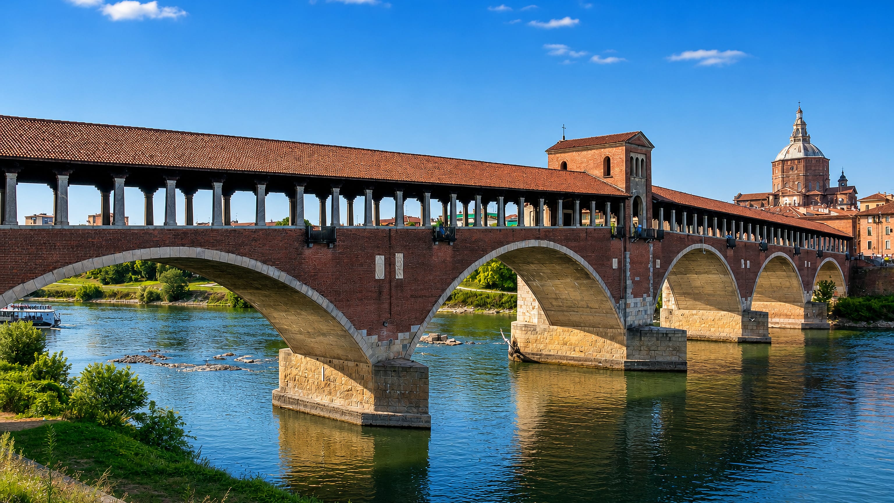Pavia's brick Ponte Coperto spanning the Ticino, the Duomo di Pavia dome rising behind the old town