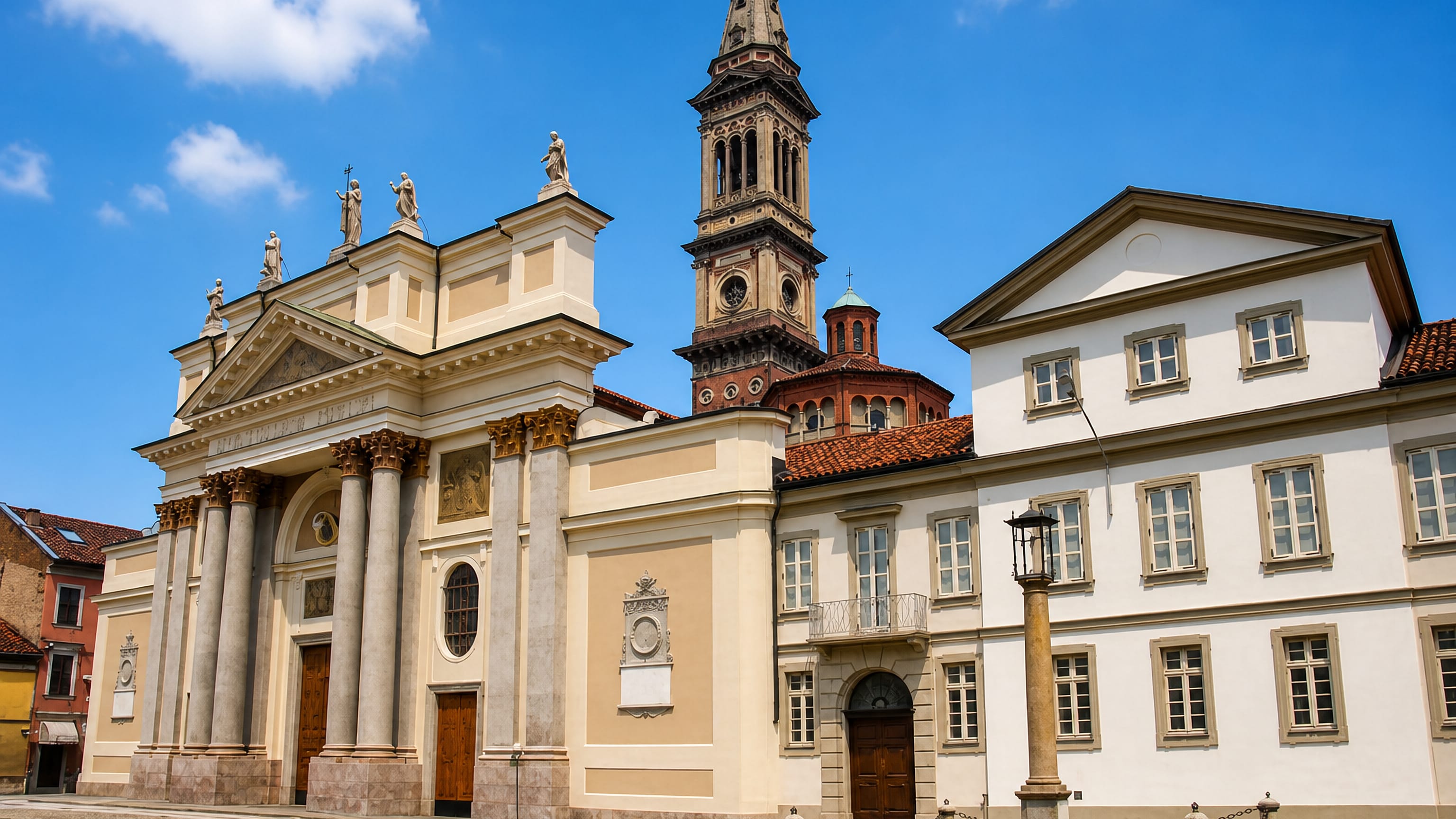Alessandria's neoclassical cathedral and its tall brick bell tower front a quiet piazza in Piemonte, Italy.