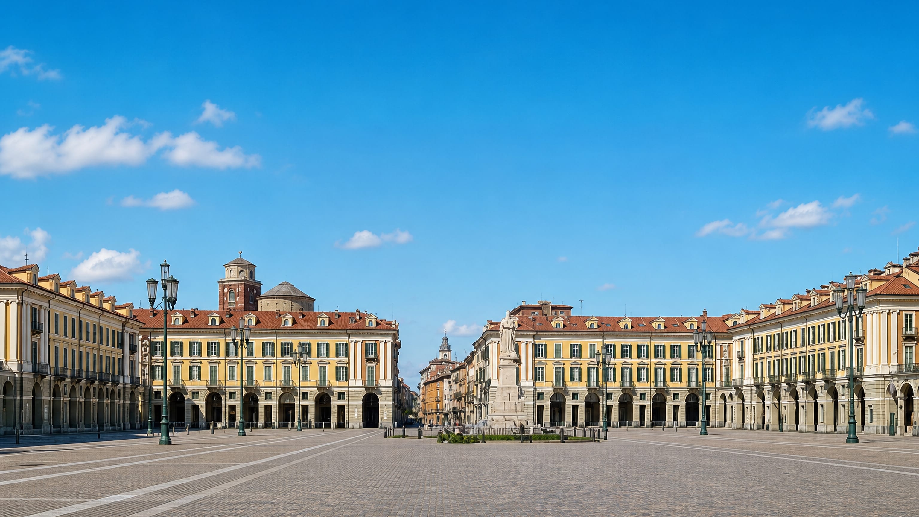 Cuneo's vast arcaded Piazza Galimberti in Piedmont, framed by yellow palazzi and a central monument