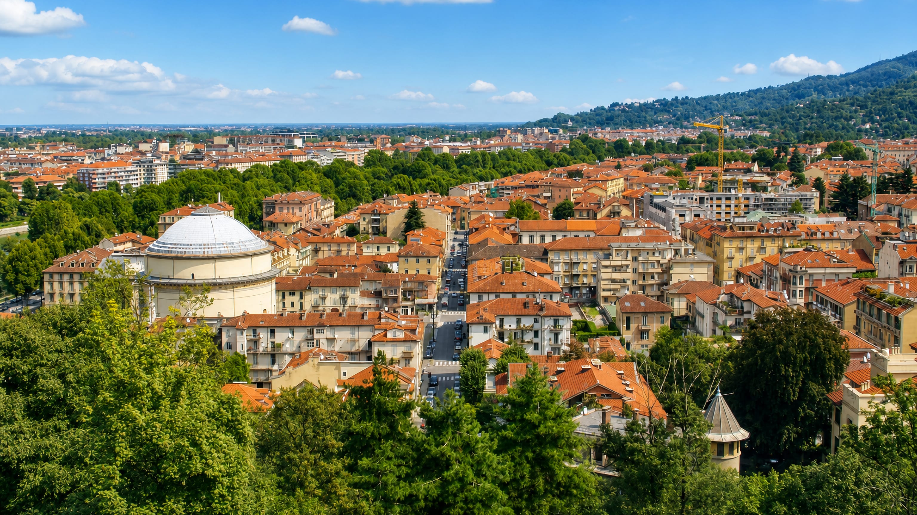 Borgo Po, Turin, seen from the hill: the domed Gran Madre di Dio church among terracotta rooftops and green slopes.