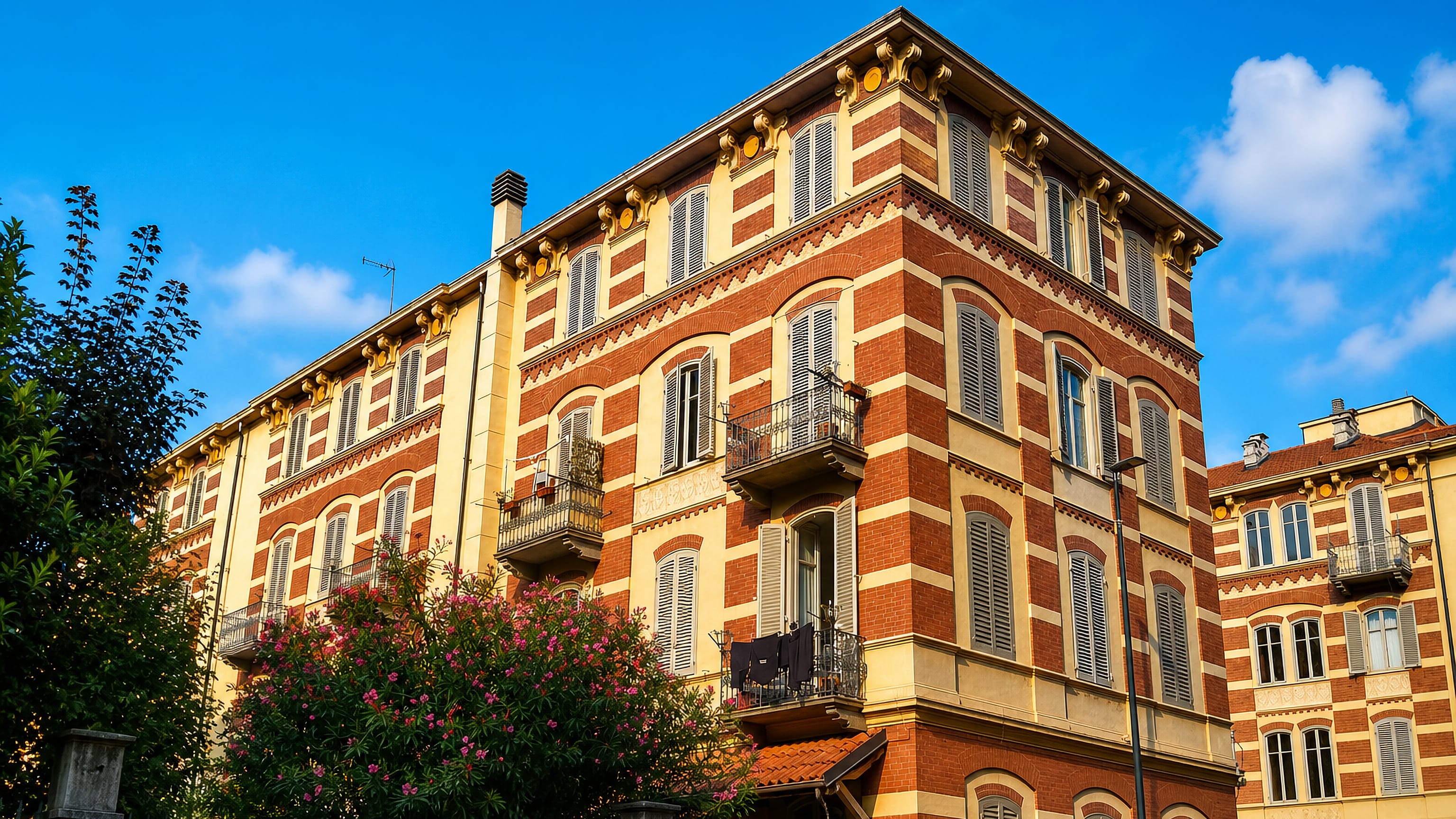 Liberty-style brick and cream apartment block with wrought-iron balconies in Crocetta, Turin.