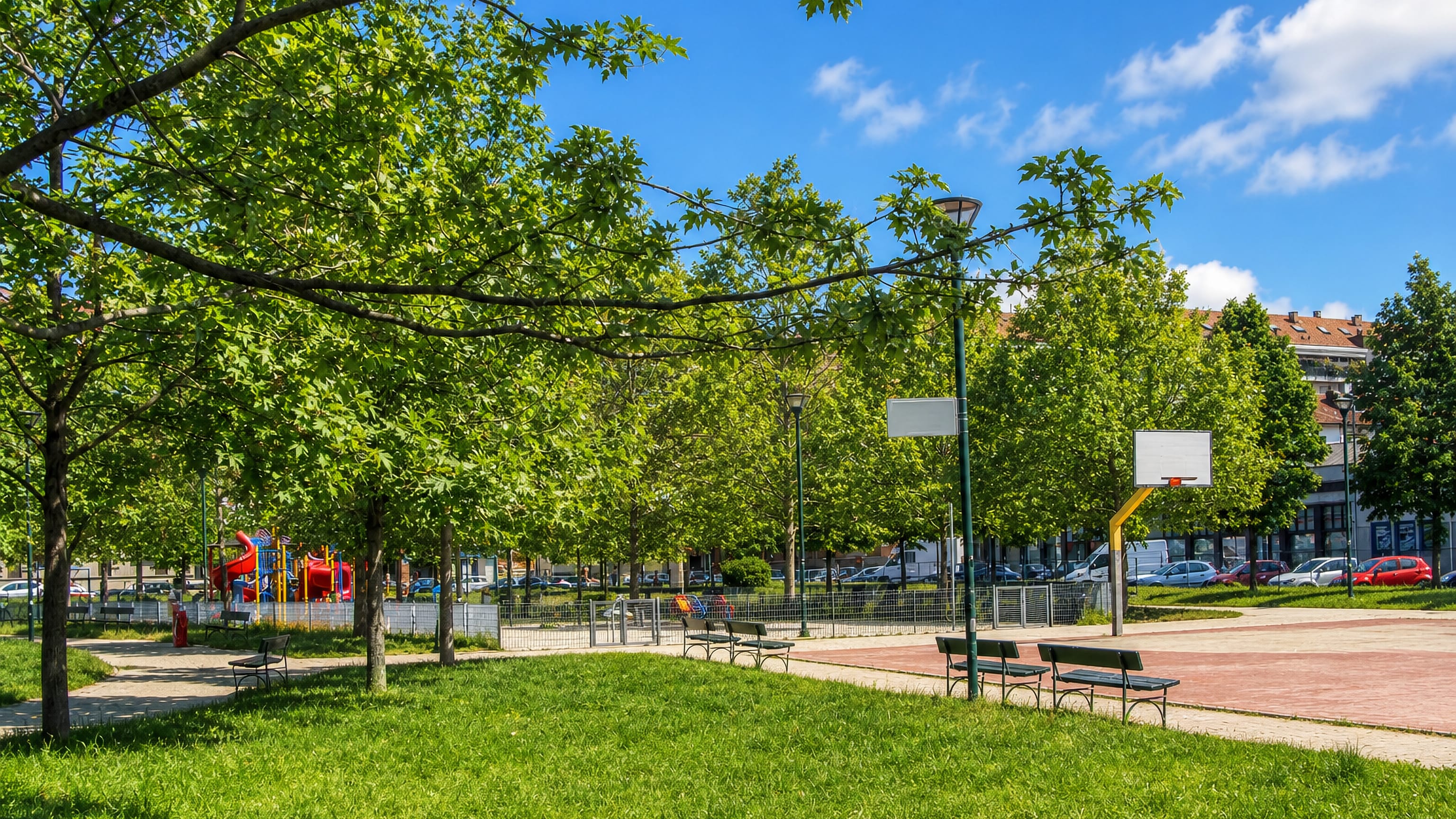Shaded neighbourhood park with benches, playground and a basketball court in Pozzo Strada, Turin.