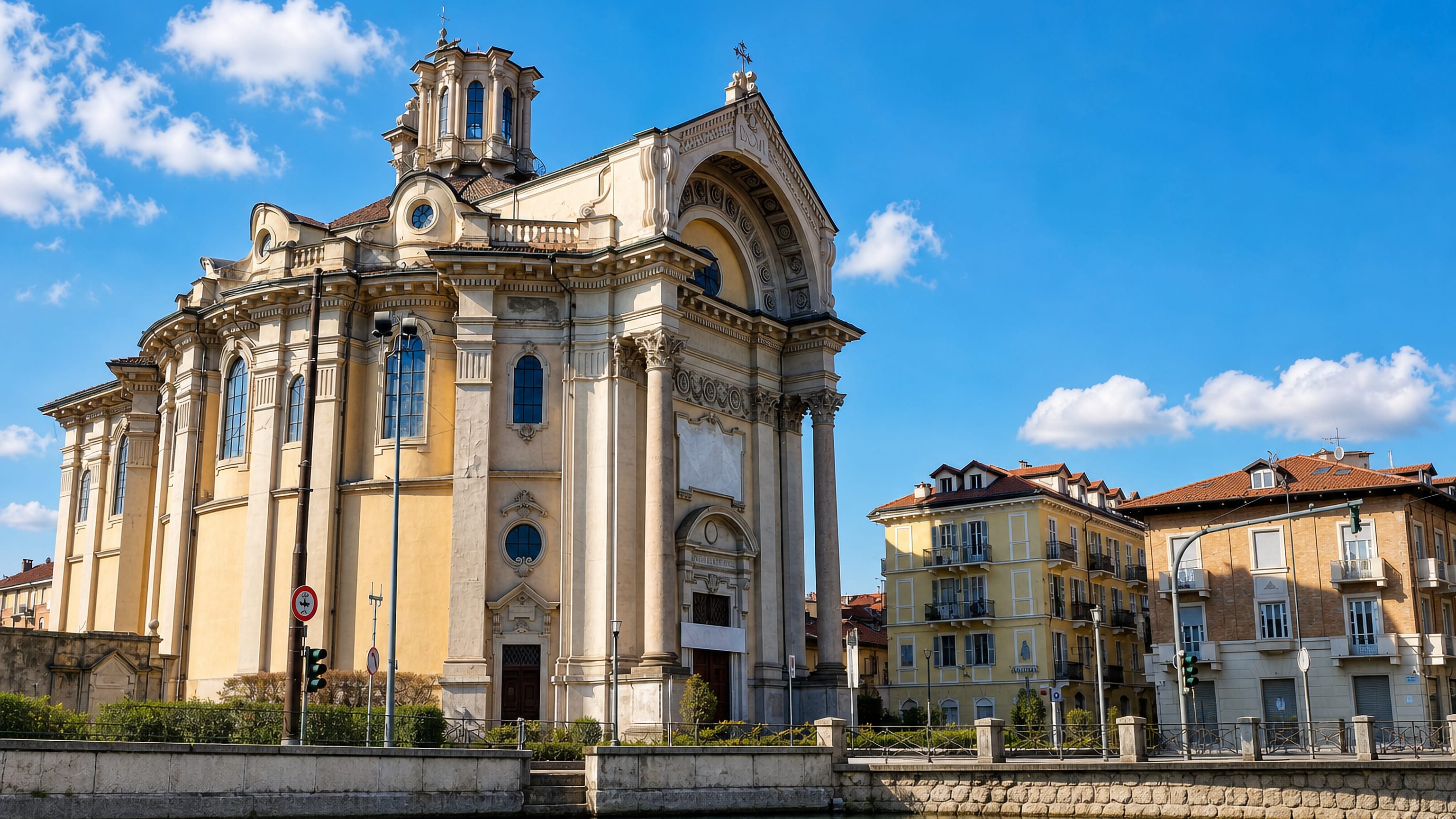 Baroque church and pastel apartment blocks along the water in the San Donato district of Turin