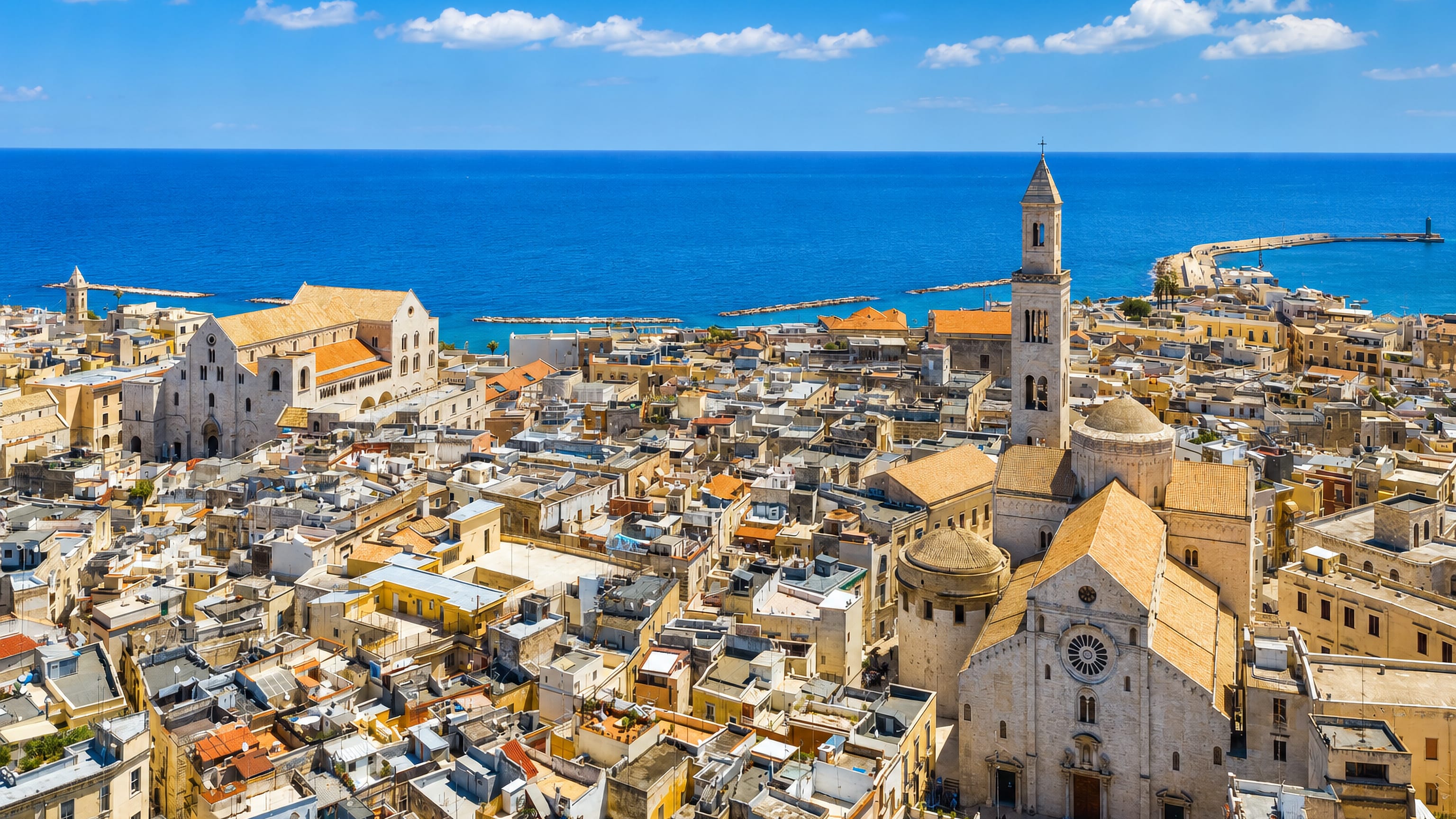 Bari's old town rooftops from above, with the cathedral campanile, the Basilica of San Nicola and the Adriatic beyond.