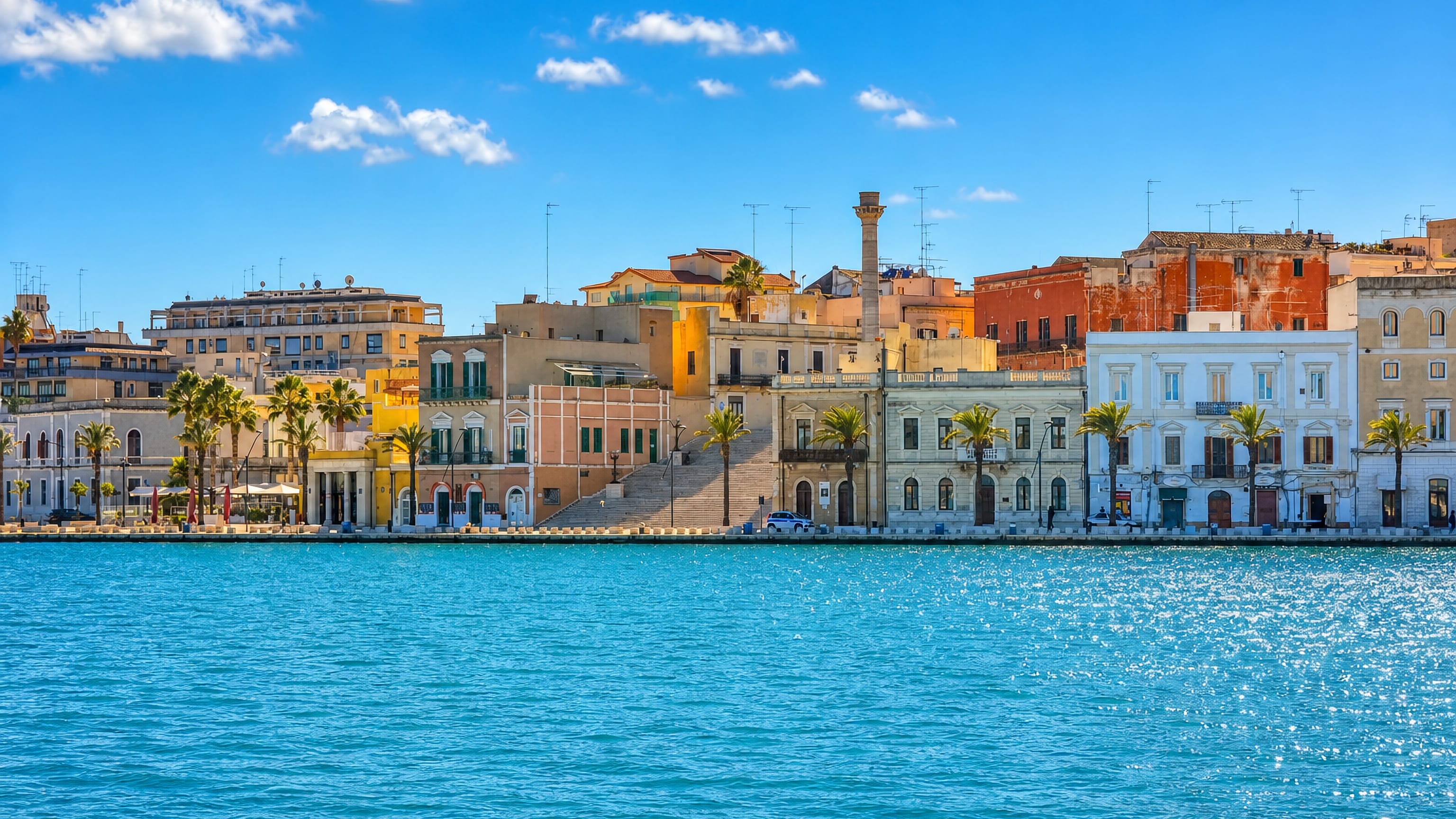 Brindisi waterfront on the inner harbour, the Roman column above the Virgilio staircase and palm-lined quay