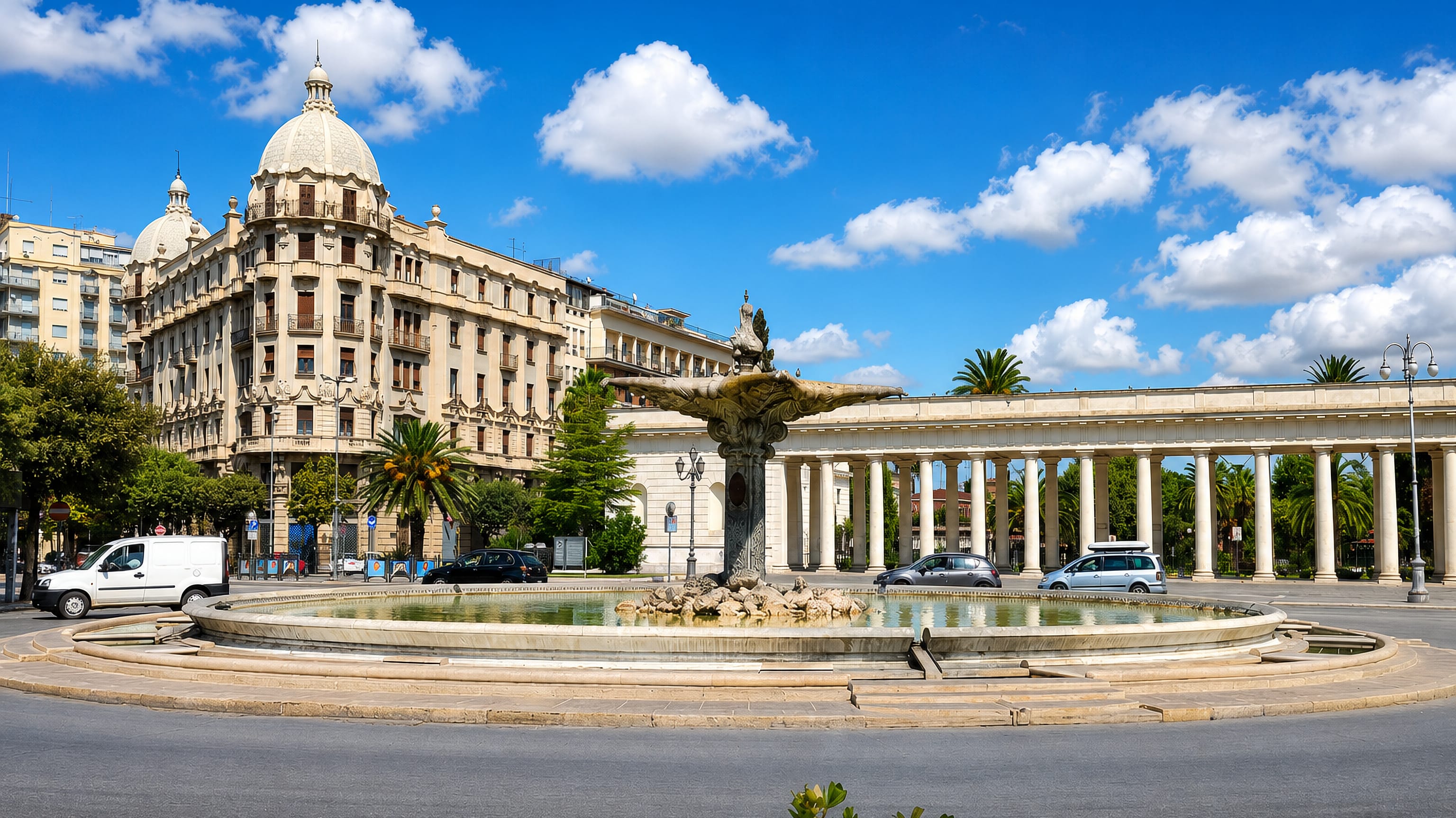 Fountain and curved colonnade on Piazza Cavour in Foggia, with a domed corner palazzo behind.
