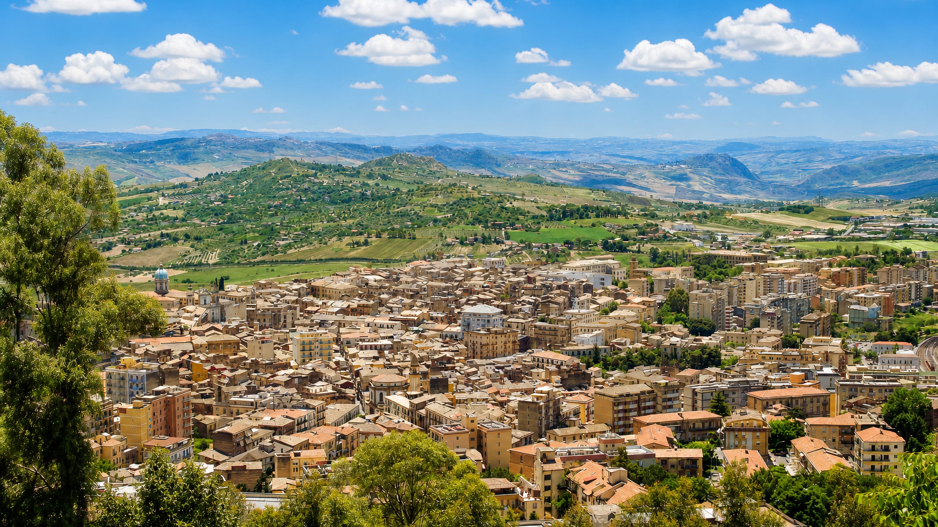 Caltanissetta, Sicily, its ochre hilltop rooftops overlooking the rolling green hills of the island's interior.