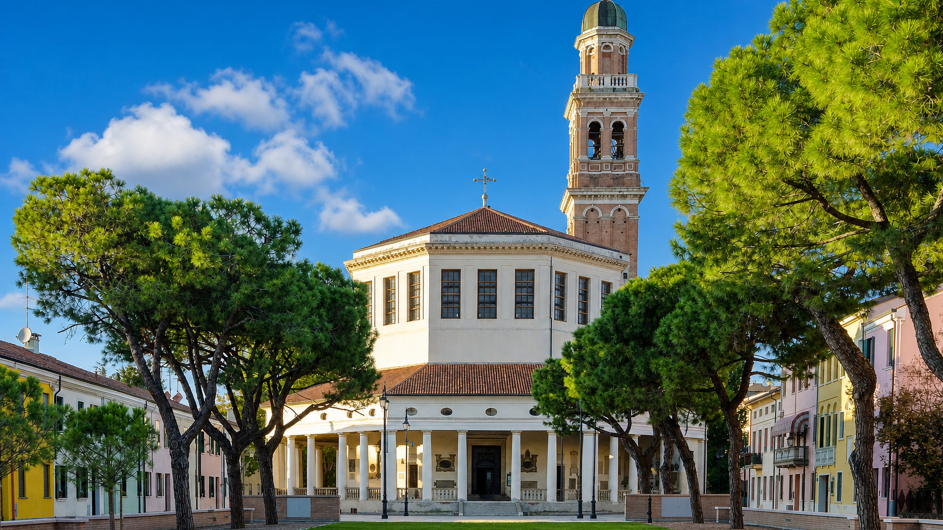 The octagonal Rotonda church and its tall bell tower framed by pines in Rovigo, Veneto