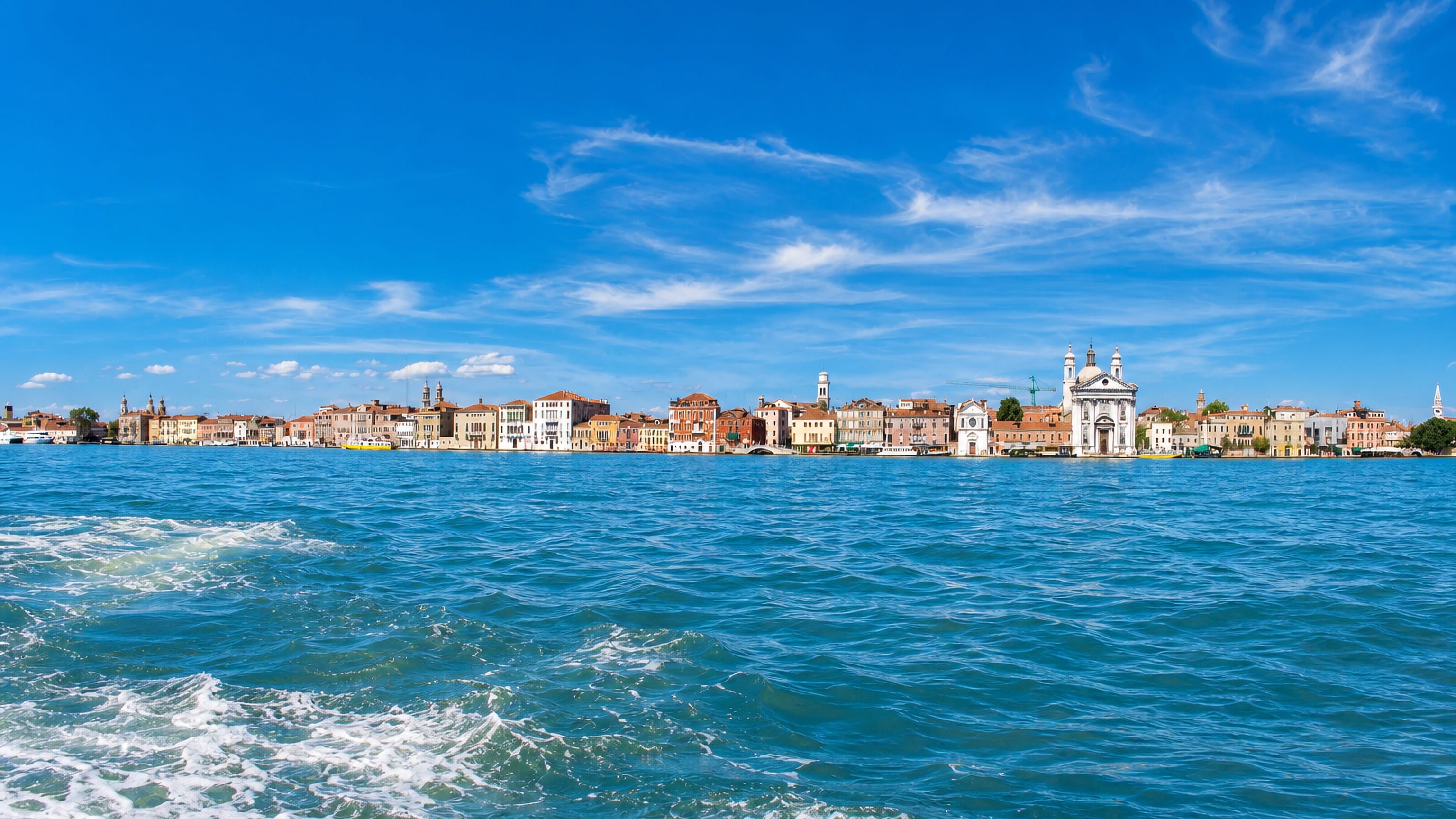 Dorsoduro's Zattere waterfront in Venice seen across the Giudecca Canal, with the white Gesuati church.