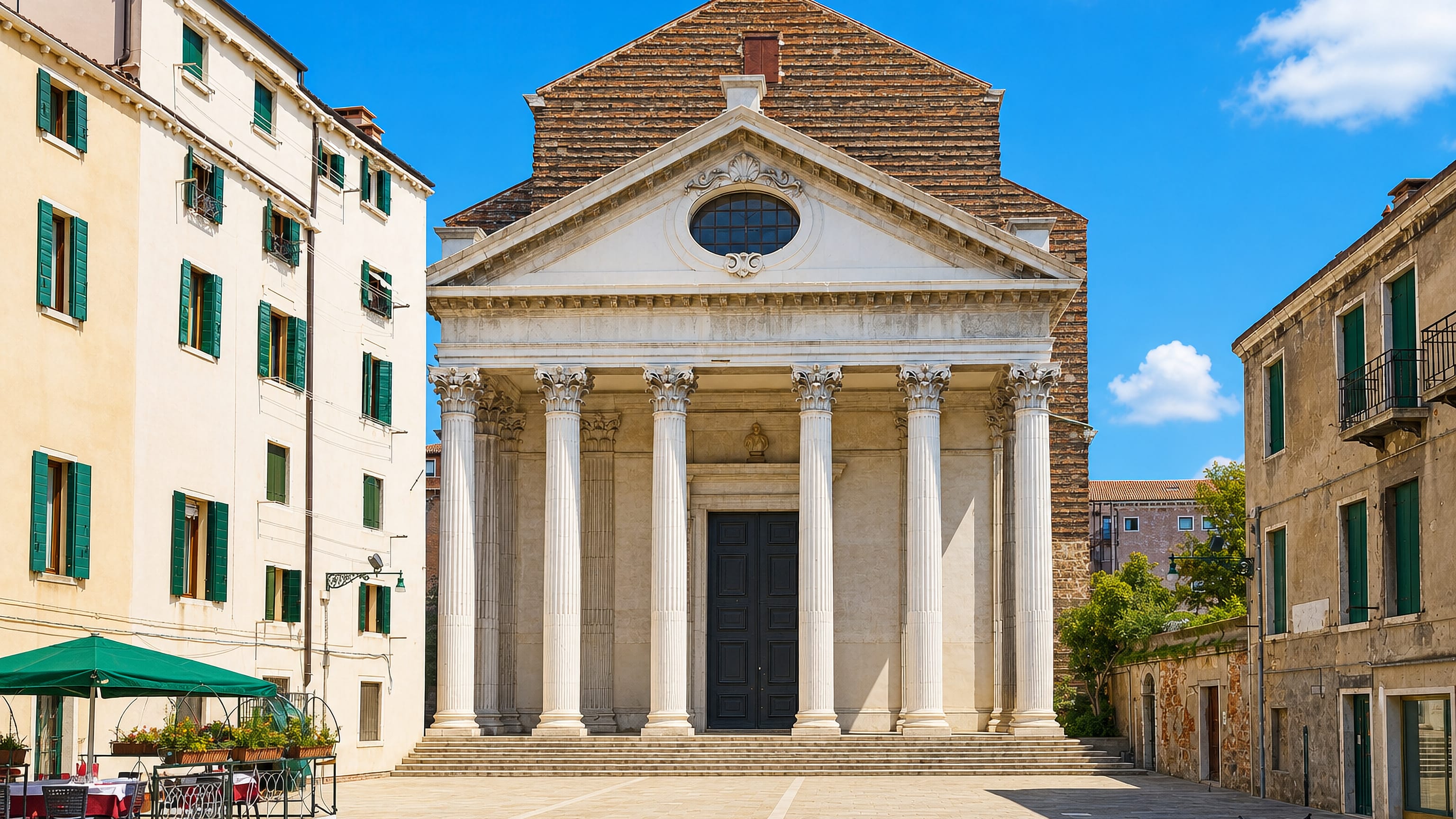 Columned Tolentini church facade on a quiet paved campo in the Santa Croce sestiere of Venice.