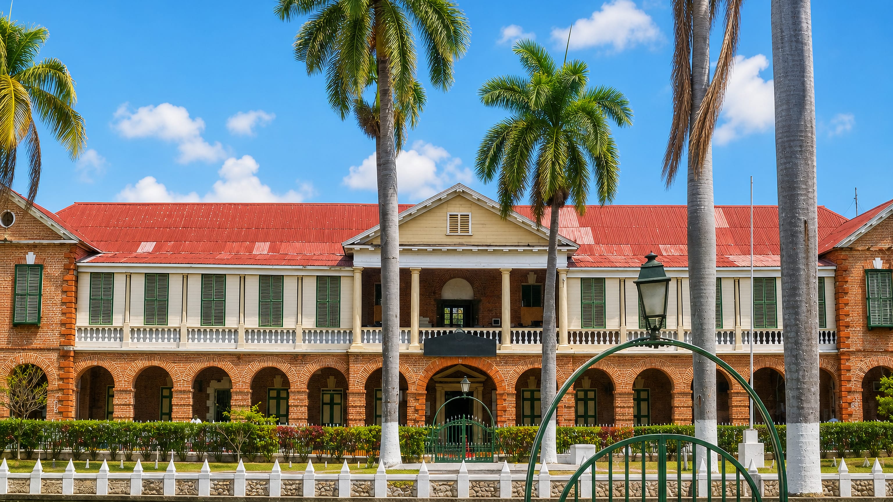 Red-roofed Georgian brick arcades and royal palms on the historic square in Spanish Town, Jamaica.