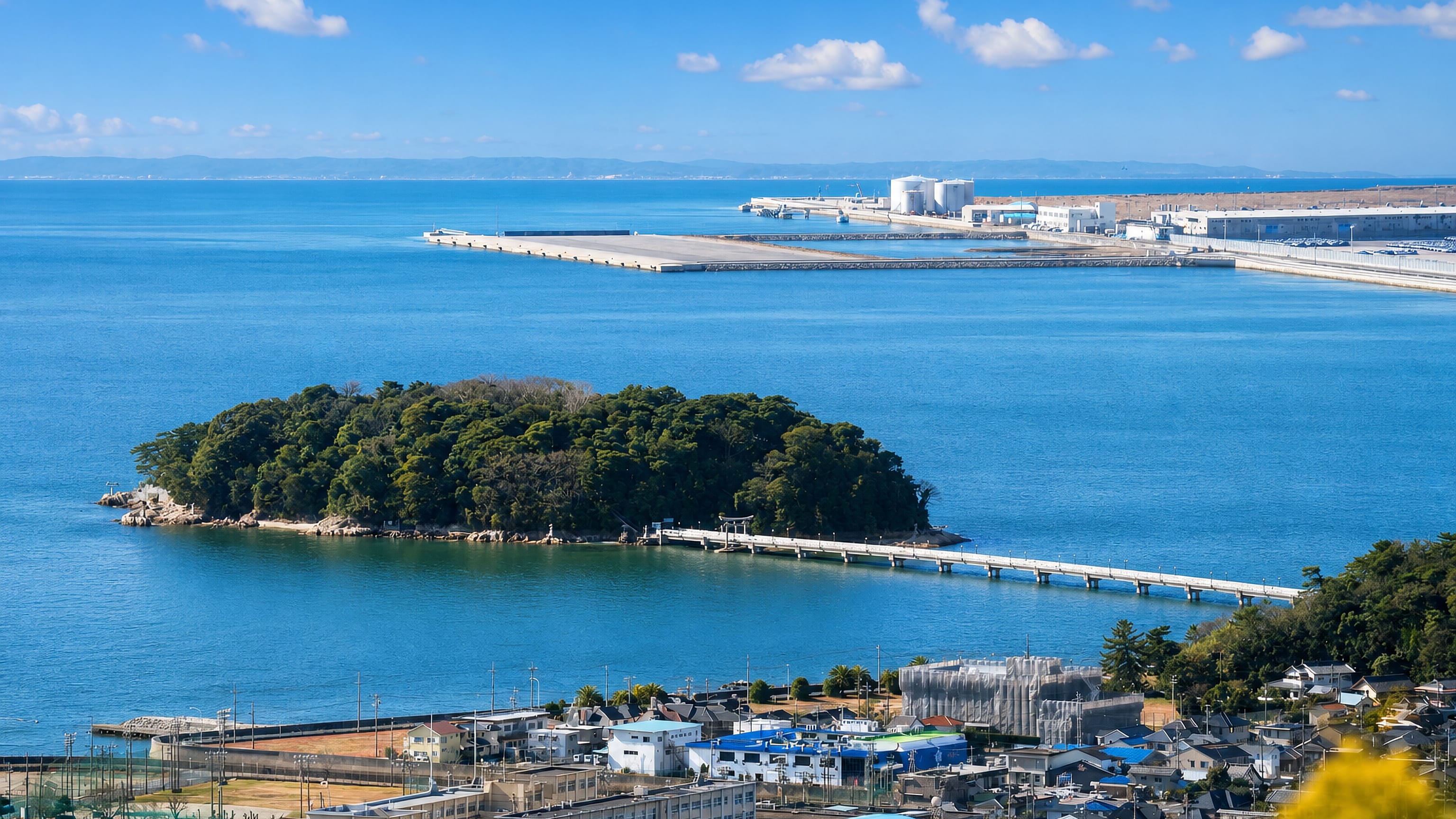 Gamagori's wooded Takeshima island linked to the shore by a long causeway bridge on Mikawa Bay.