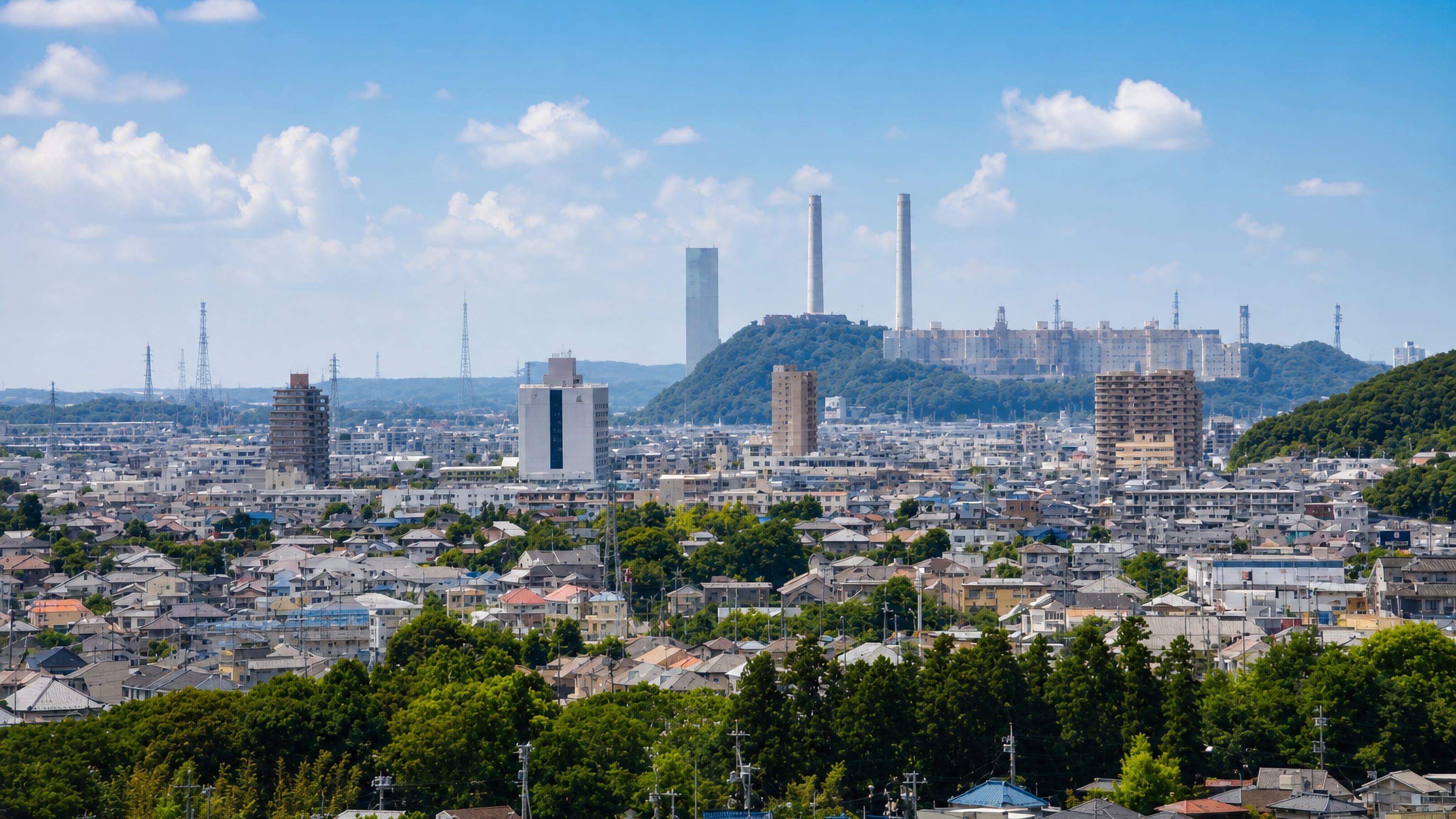 Suburban rooftops of Kimitsu, Chiba, spreading toward the tall stacks of its coastal steelworks