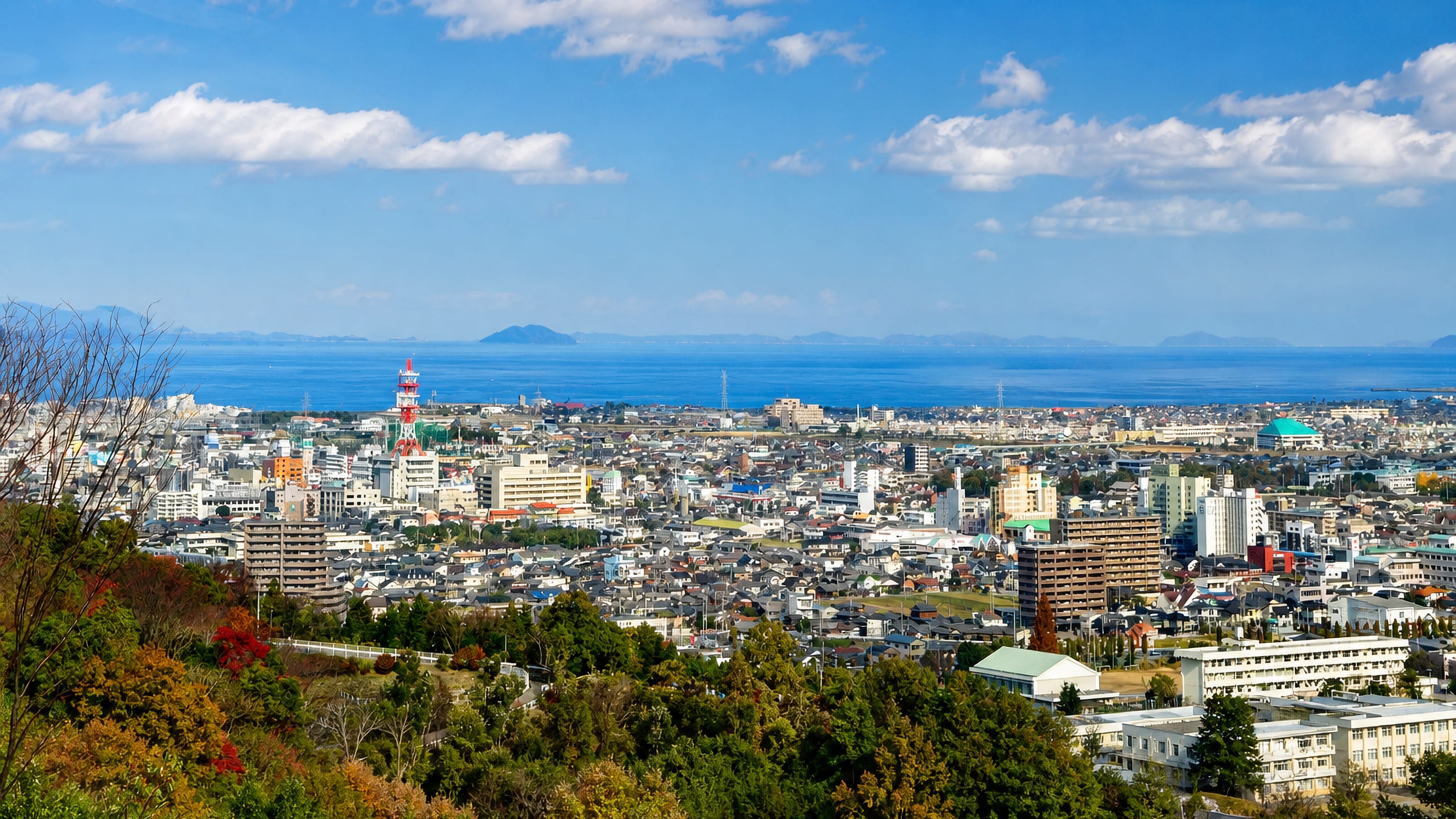 Niihama, Japan, seen from wooded hills, its townscape stretching to the Seto Inland Sea and distant islands.