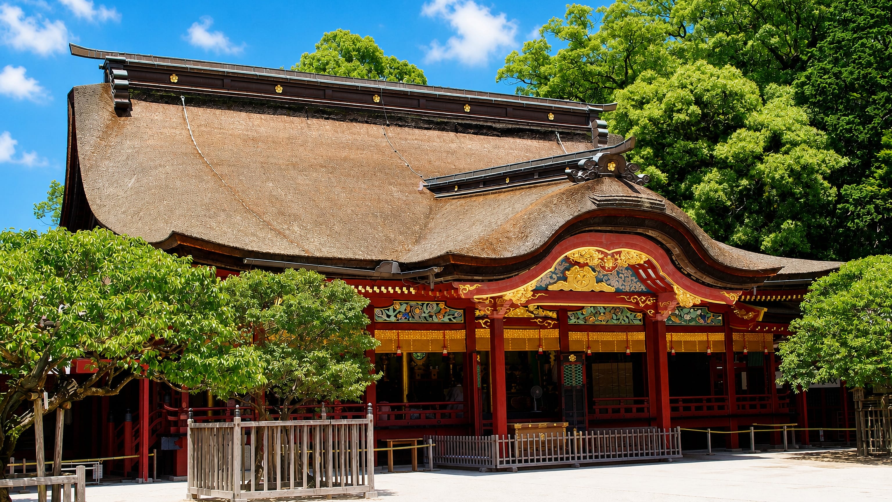 The red-lacquered main hall of Dazaifu Tenmangu shrine beneath its thatched roof in Dazaifu, Japan