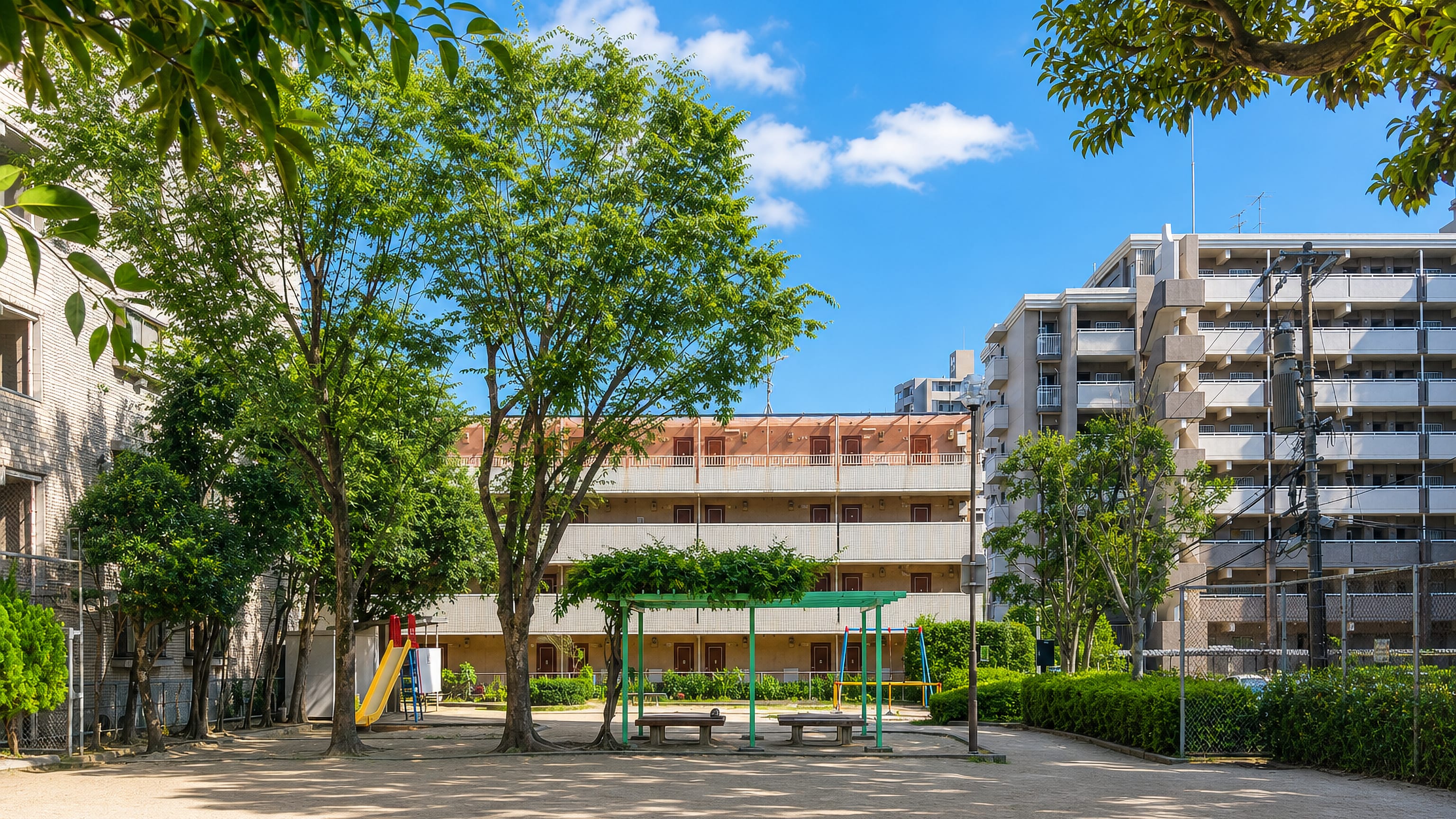 Neighbourhood playground framed by mid-rise apartment blocks in Befu, Fukuoka.