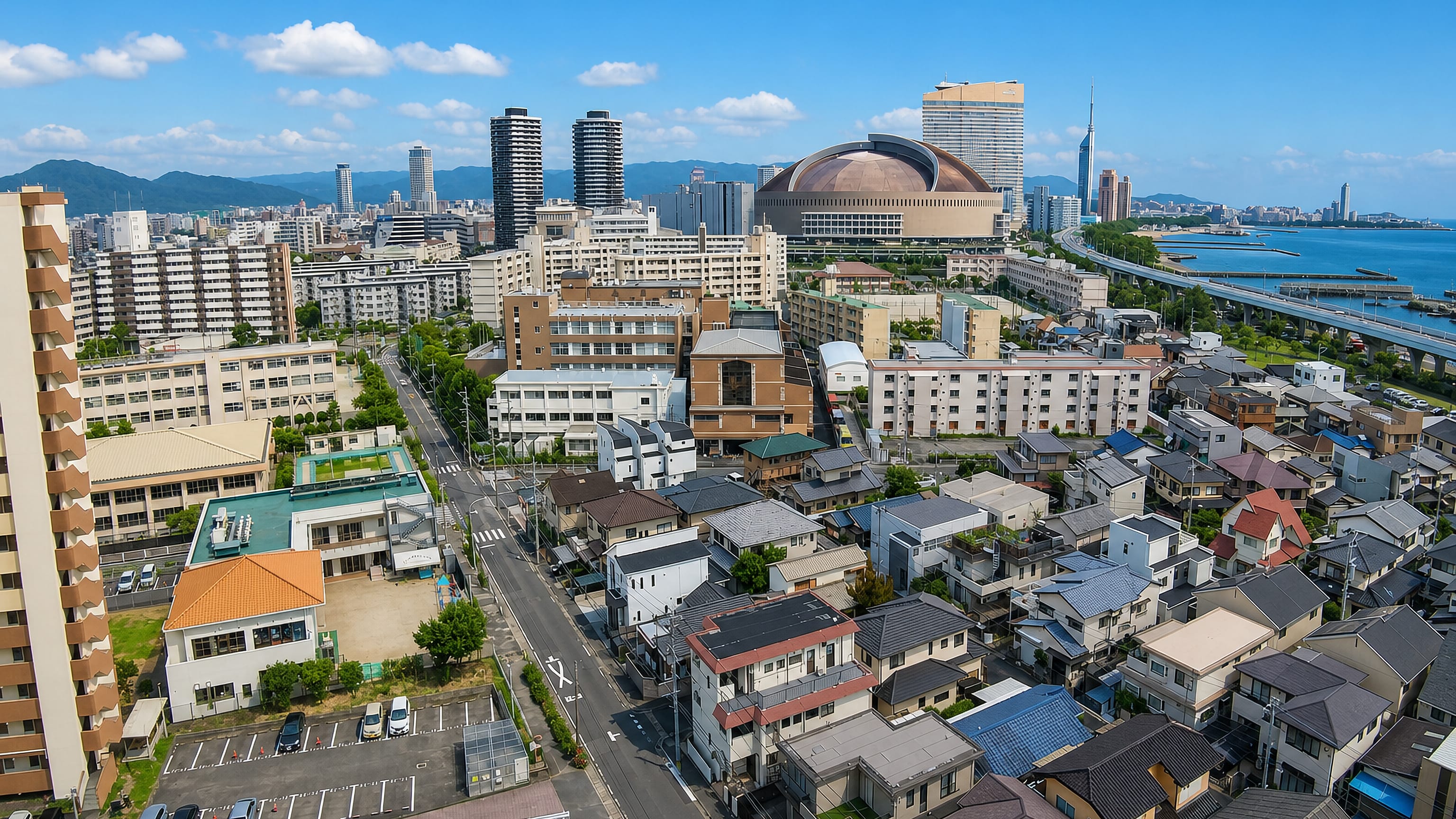 Aerial view over Fukuhama, Fukuoka, toward Fukuoka PayPay Dome, Fukuoka Tower and Hakata Bay.