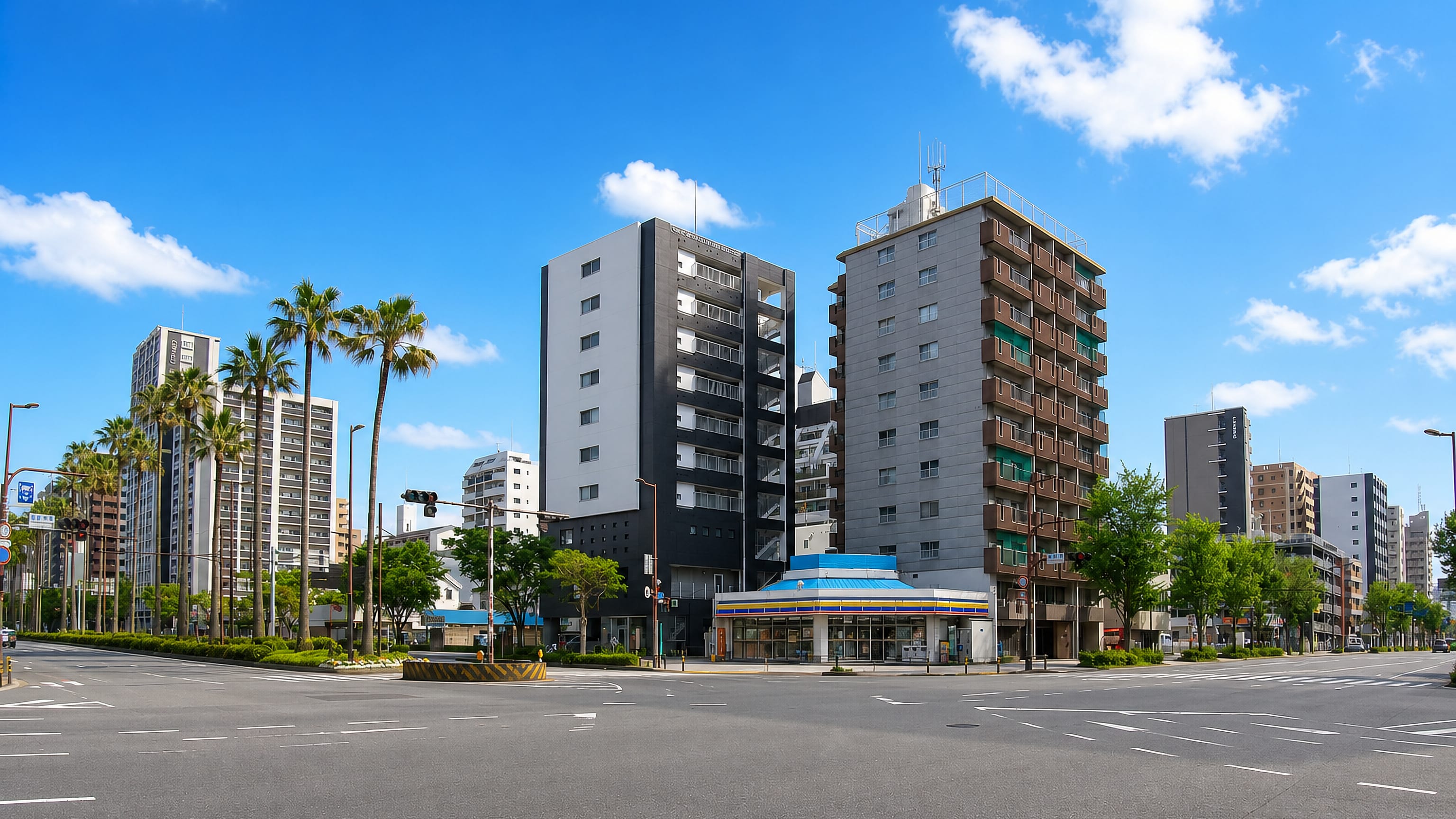 Palm-lined crossing with apartment towers and a corner convenience store in Kamiyamachi, Fukuoka.