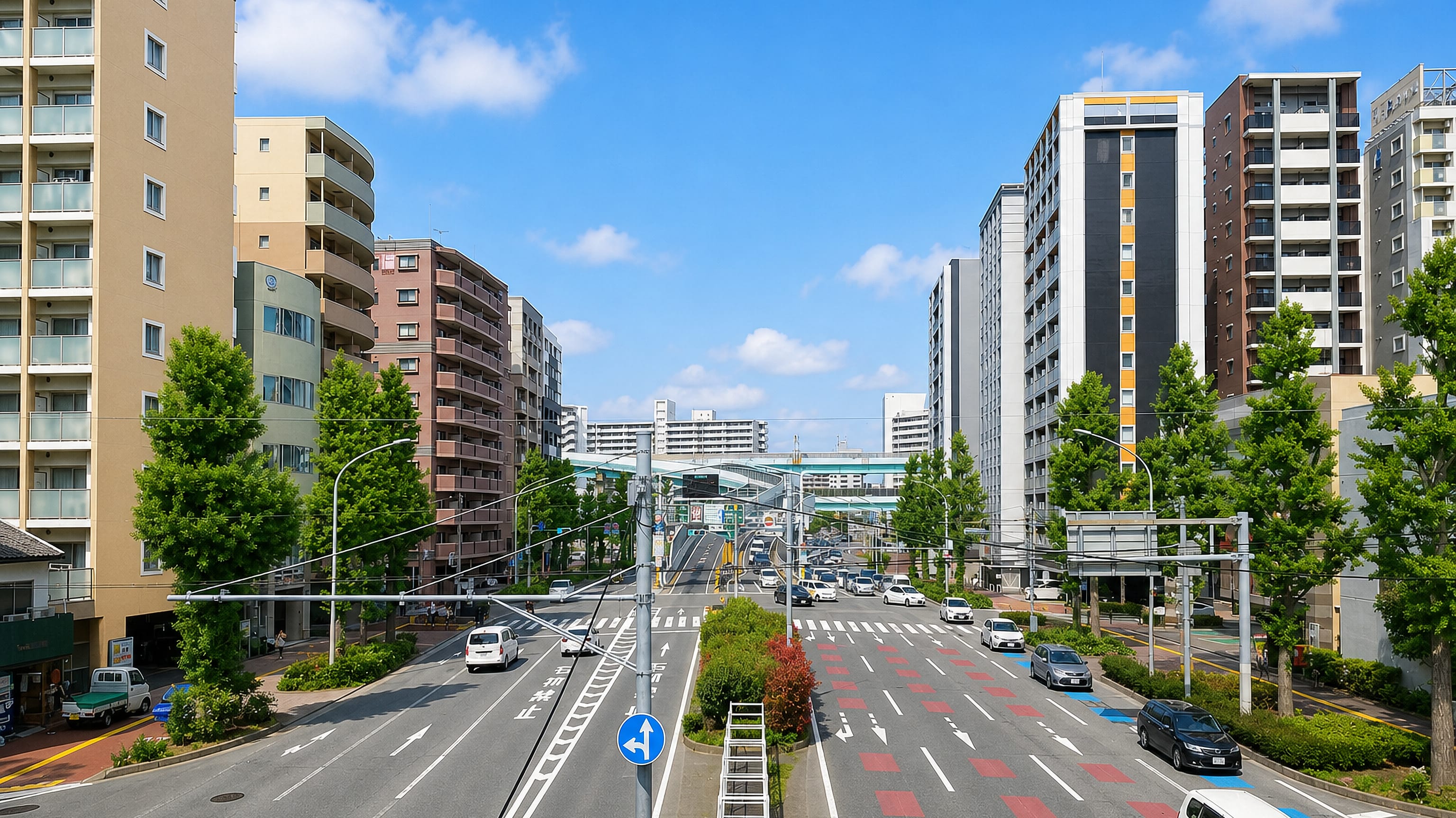 Wide multi-lane boulevard lined with apartment towers and ginkgo trees in Naka-gofukumachi, Fukuoka.