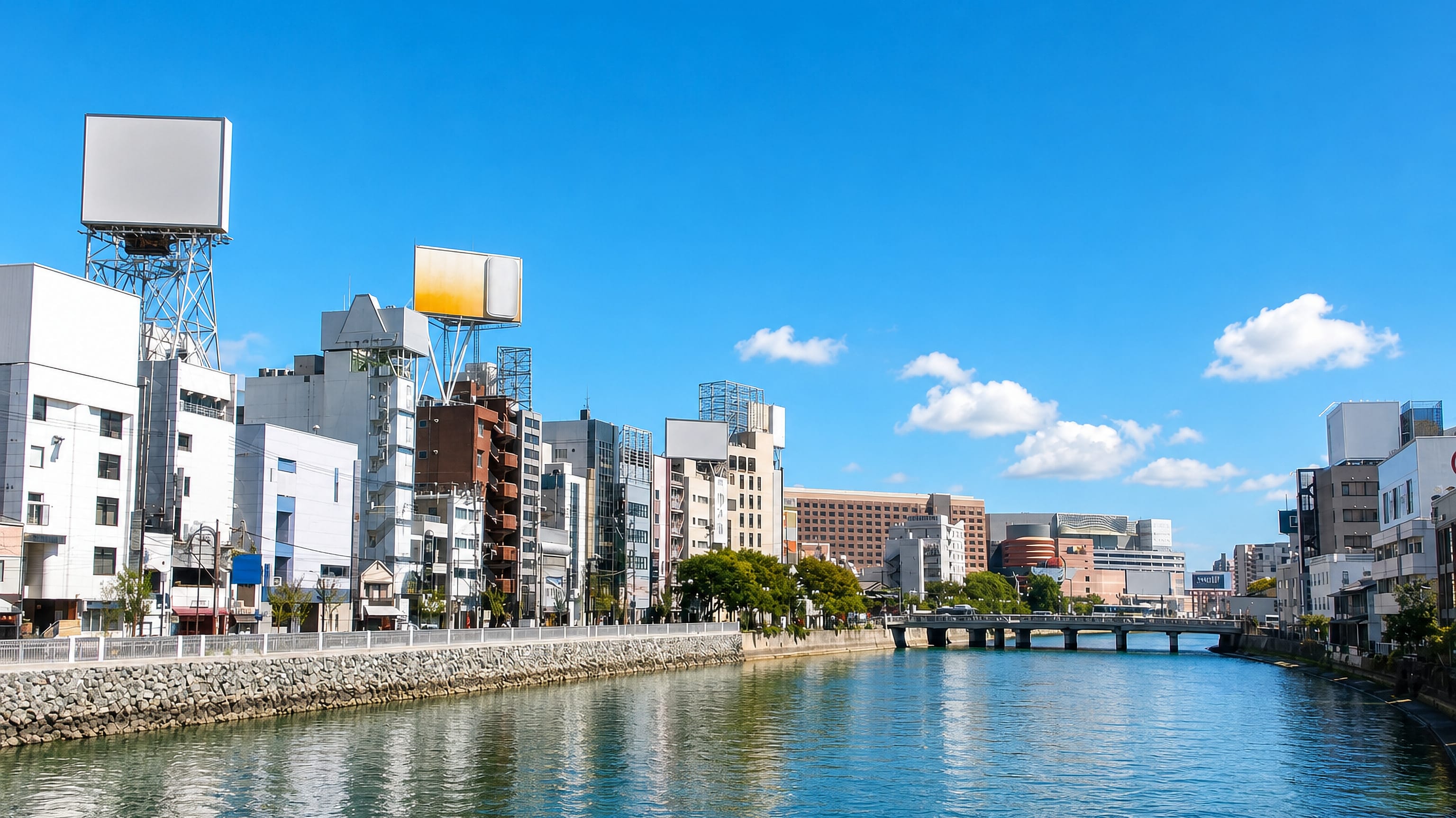 Nakasu's riverside blocks and rooftop billboards along the Naka River in Fukuoka under a clear sky.