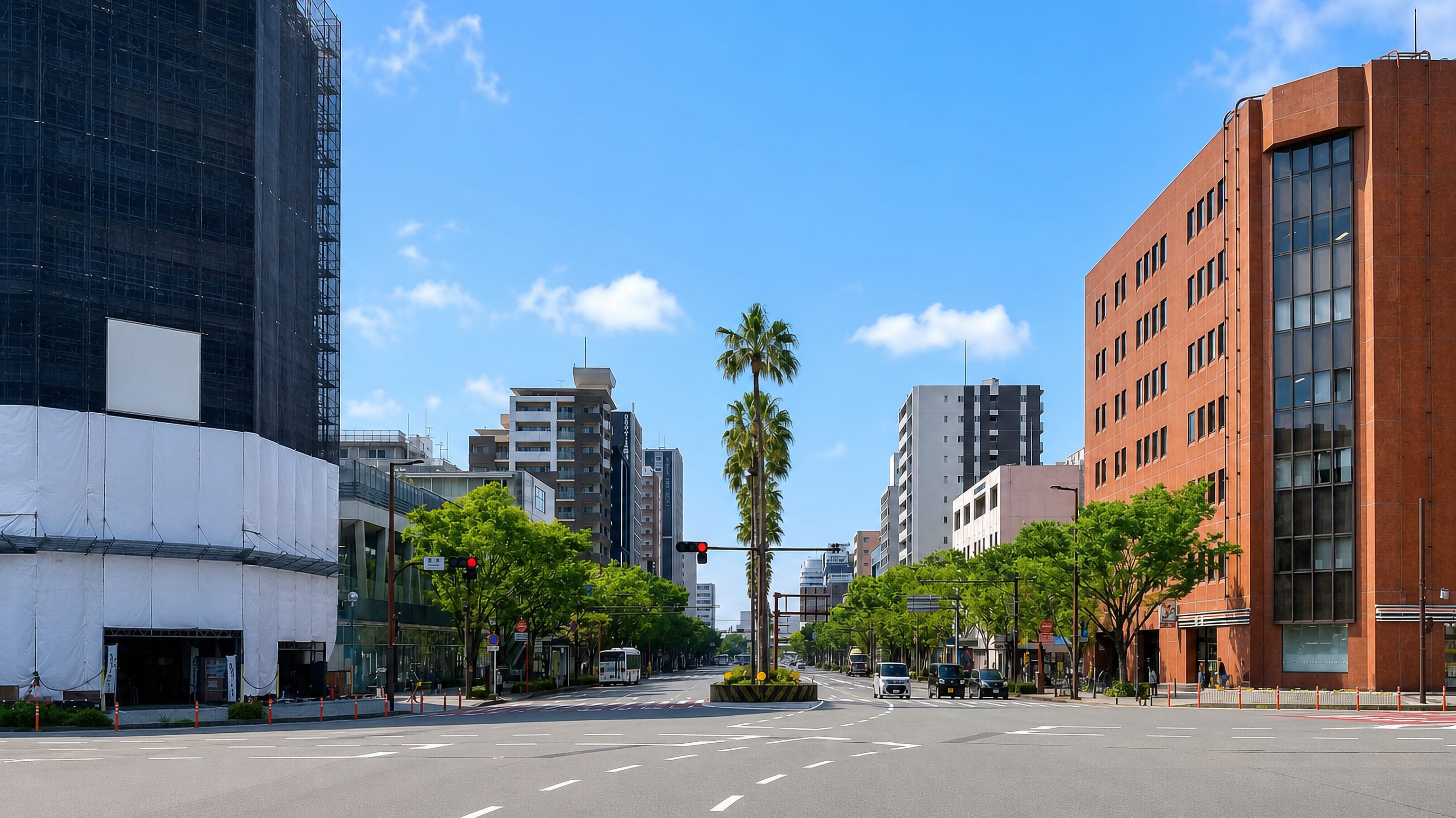 Wide boulevard with a brick office block and a palm tree in Narayamachi, Fukuoka.
