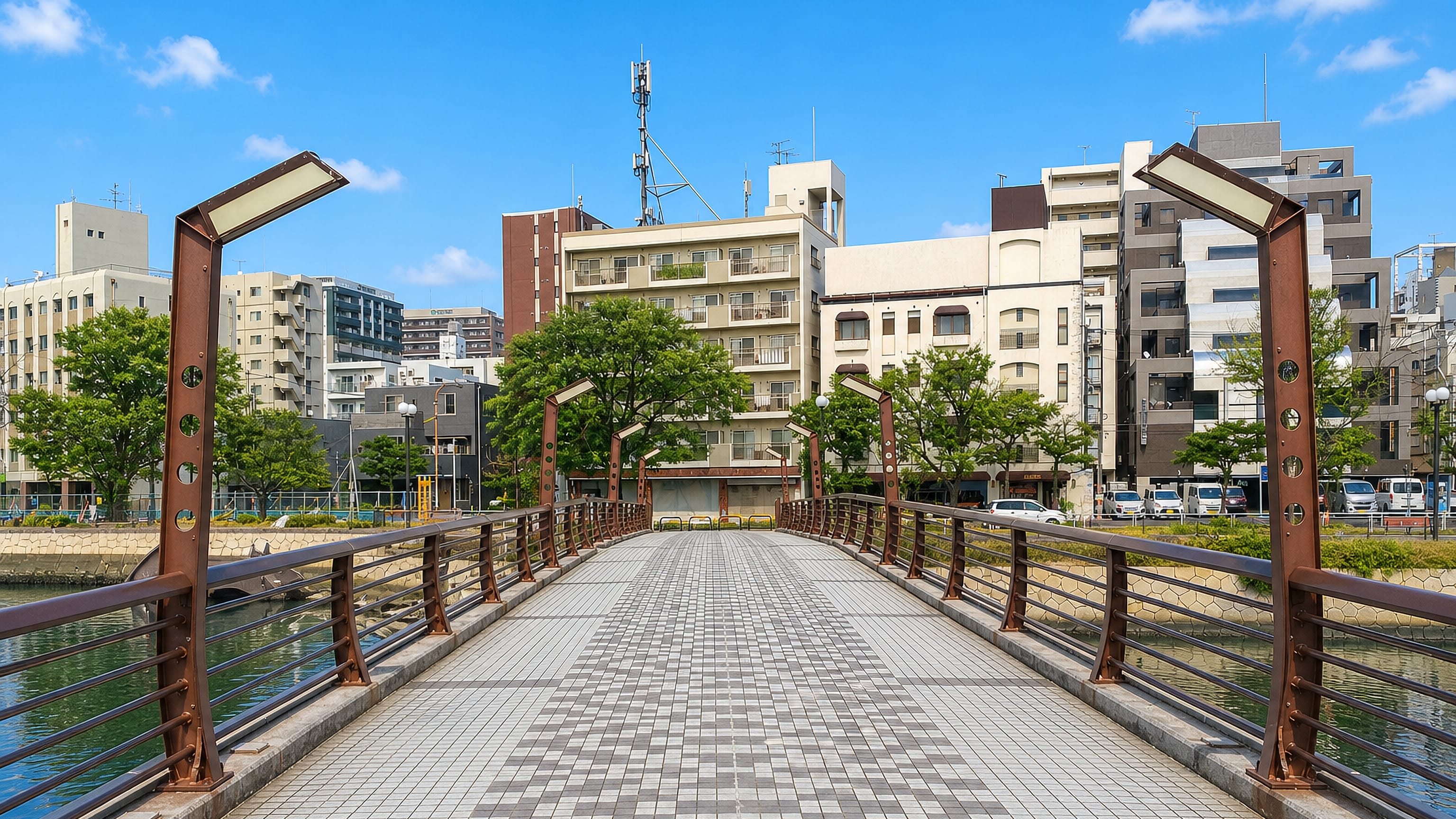 Pedestrian bridge over a canal fronted by modern apartment blocks in Susakimachi, Fukuoka.