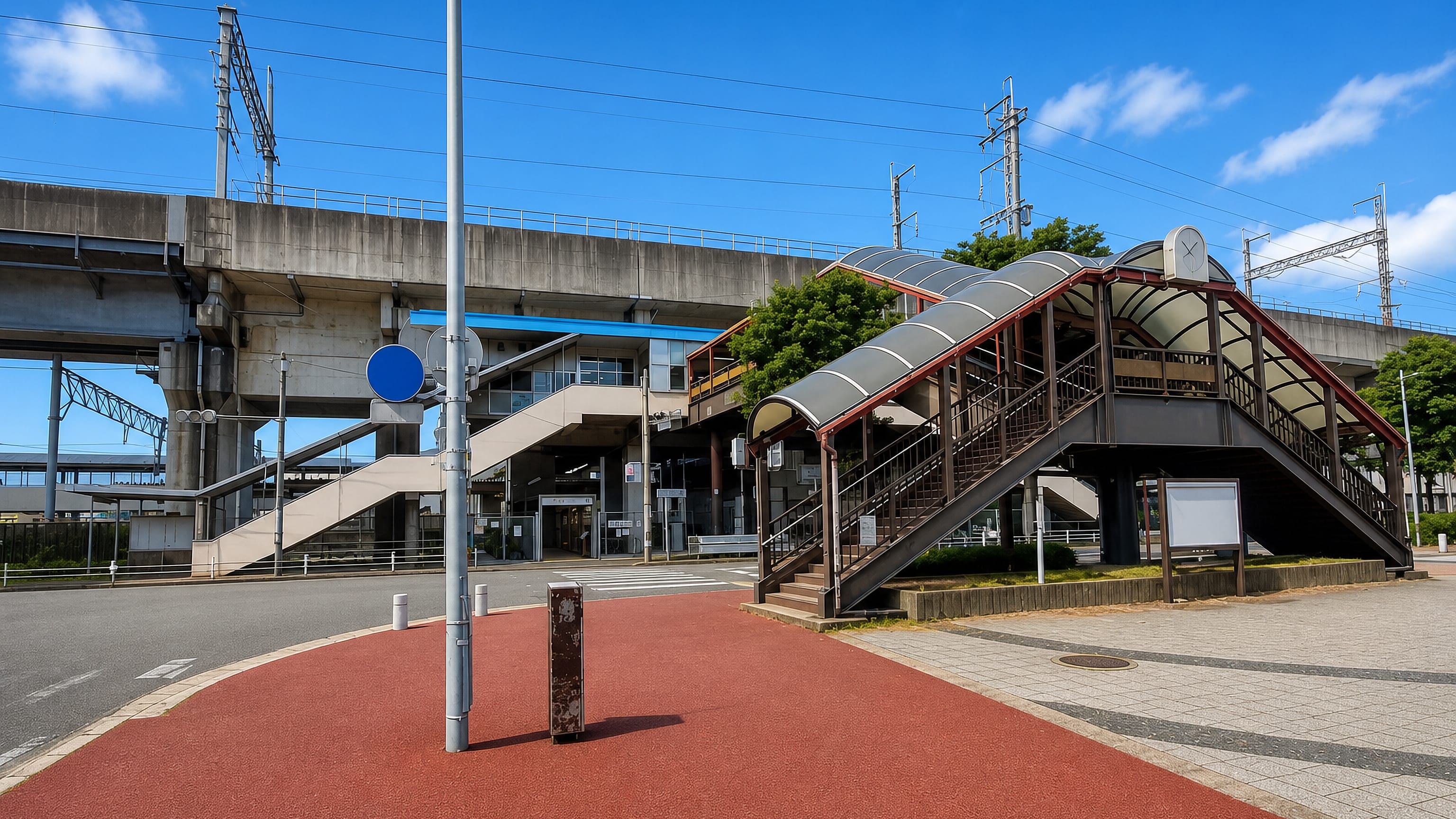 Elevated railway viaduct and covered footbridge at Takeshita Station, Fukuoka, on a sunny day.