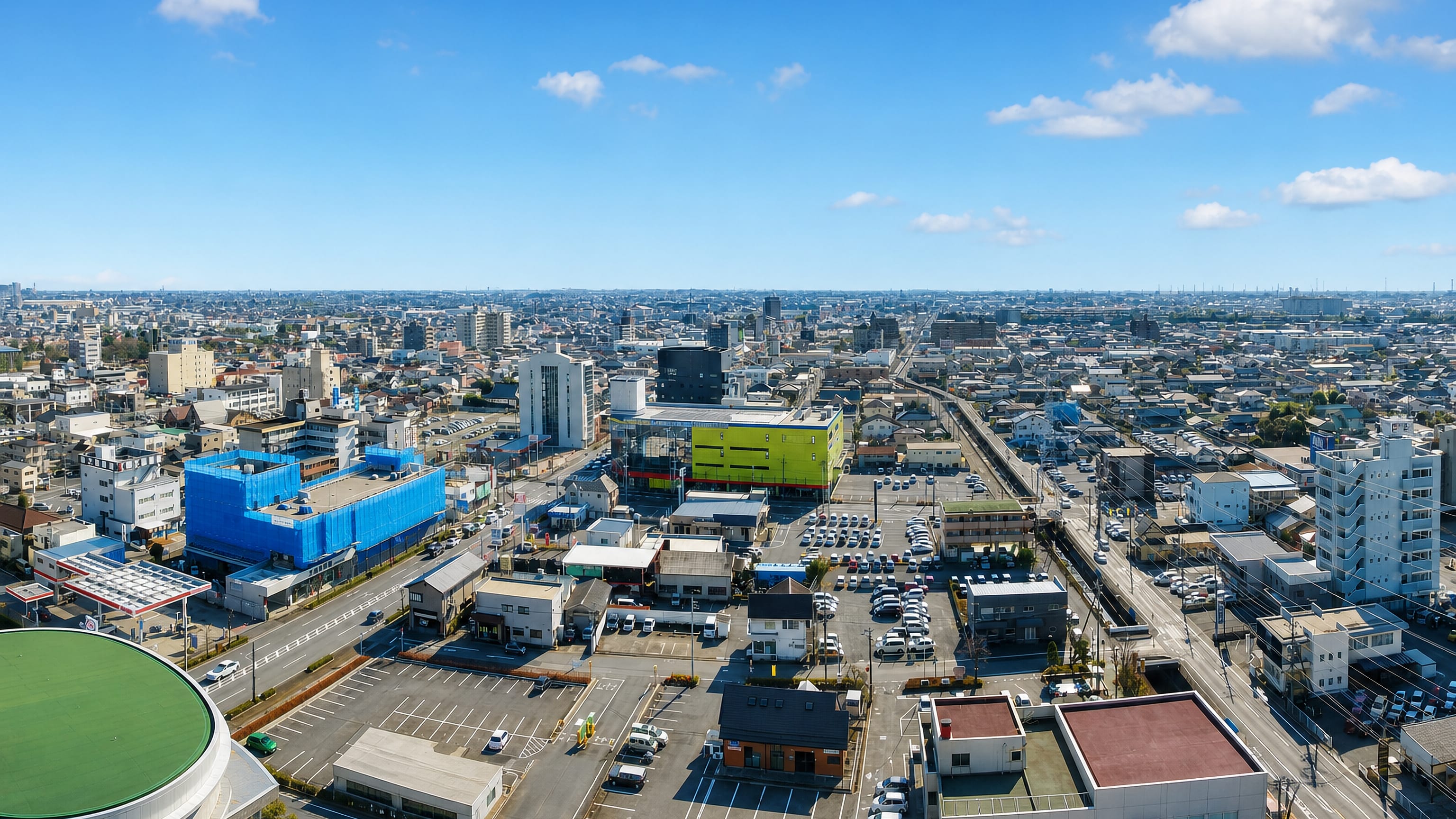 Aerial view of Ota, Gunma, Japan, low-rise blocks and an arena stretching to the Kanto plain horizon.