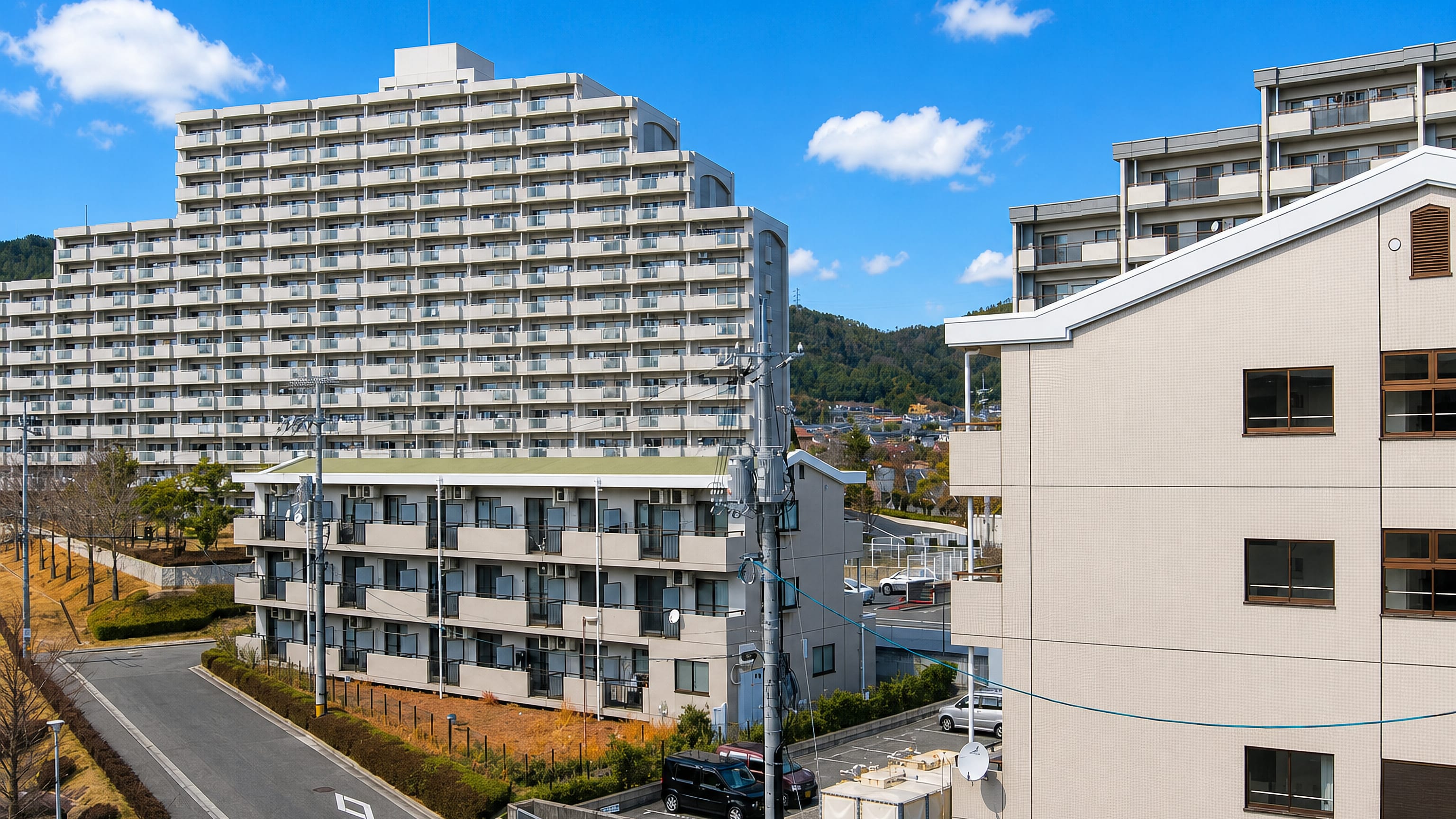 Hillside apartment blocks and low-rise housing below wooded hills in Higashihiroshima, Japan.