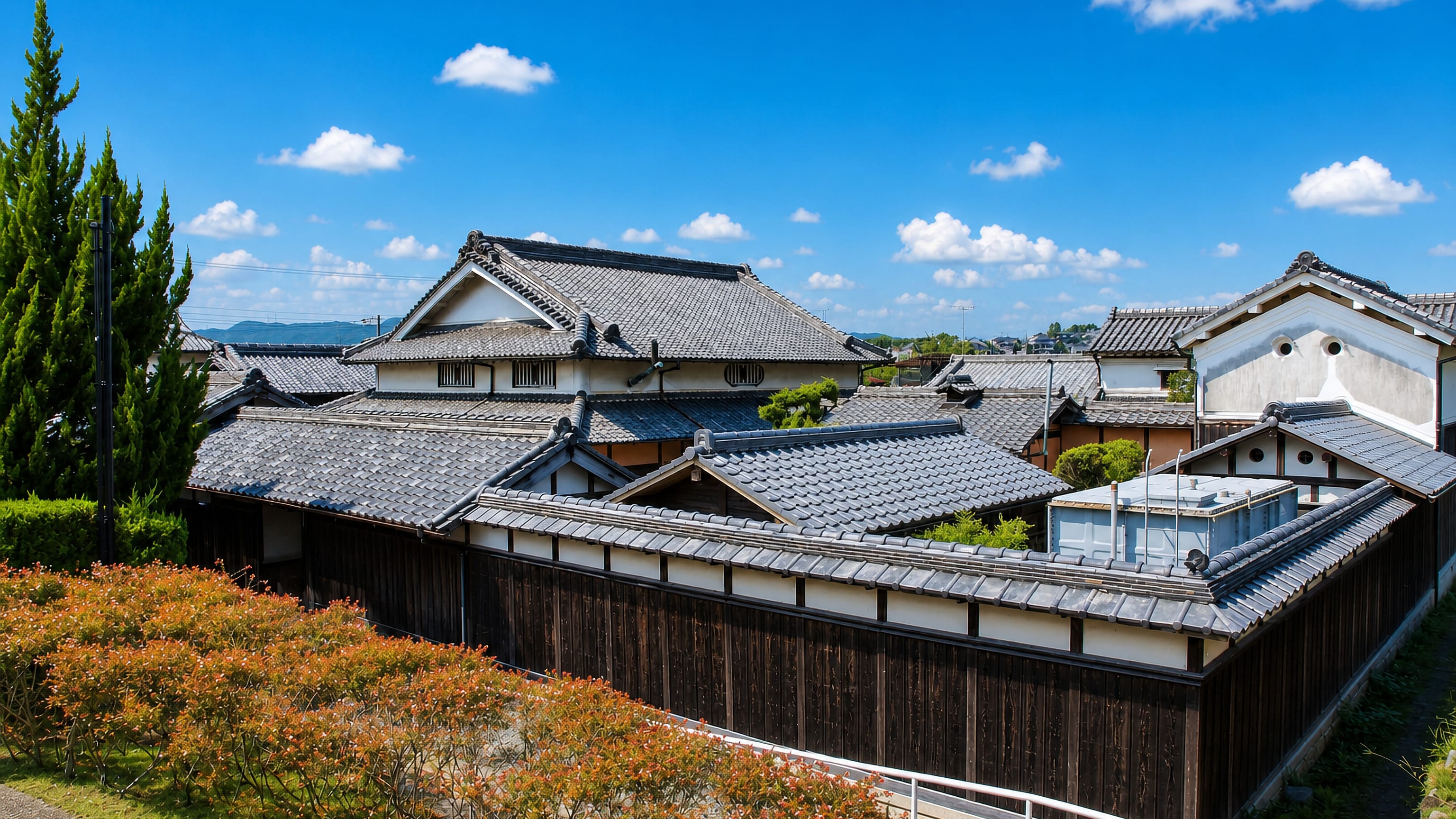 Tiled roofs and a wooden storehouse wall of a traditional residence in Kawanishi, Hyogo.