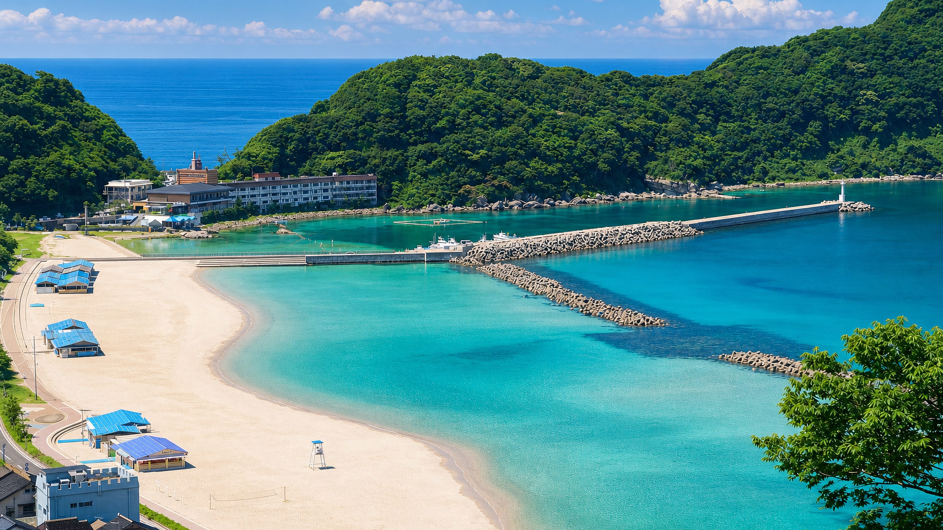Takeno Beach on the Sea of Japan coast at Toyooka, Hyogo, with turquoise water, breakwater and forested headlands.