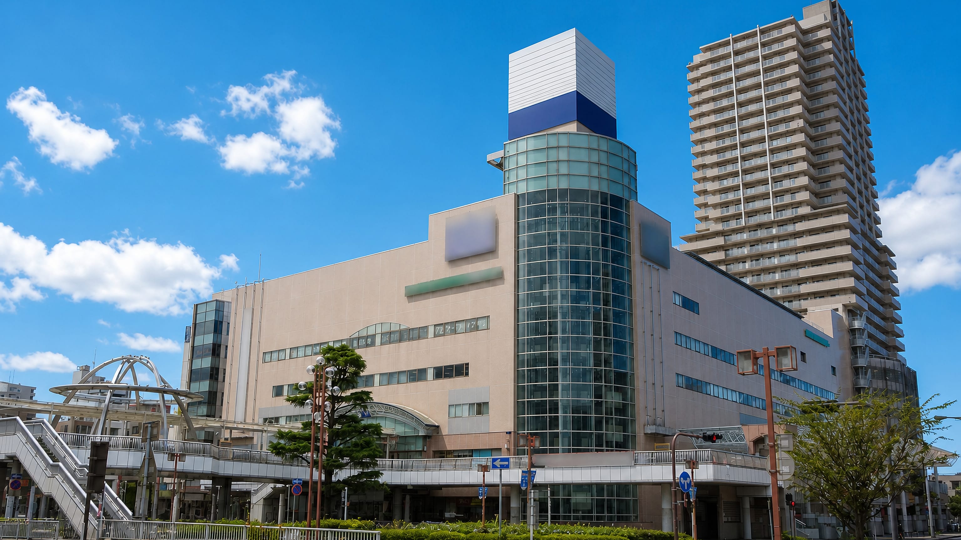 Tsuchiura station-front plaza with a glass-fronted shopping complex, pedestrian deck and residential high-rise