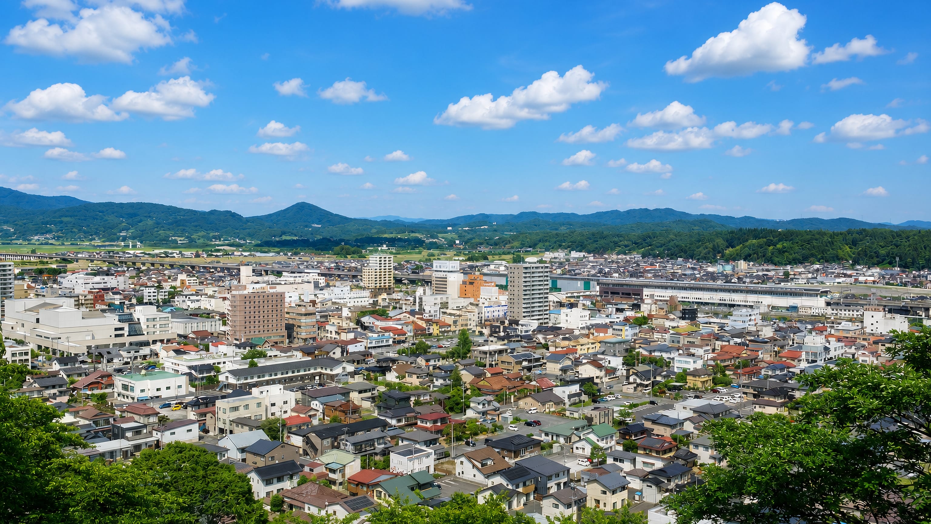 Hillside view over the low-rise city centre and surrounding mountains in Ichinoseki, Iwate, Japan