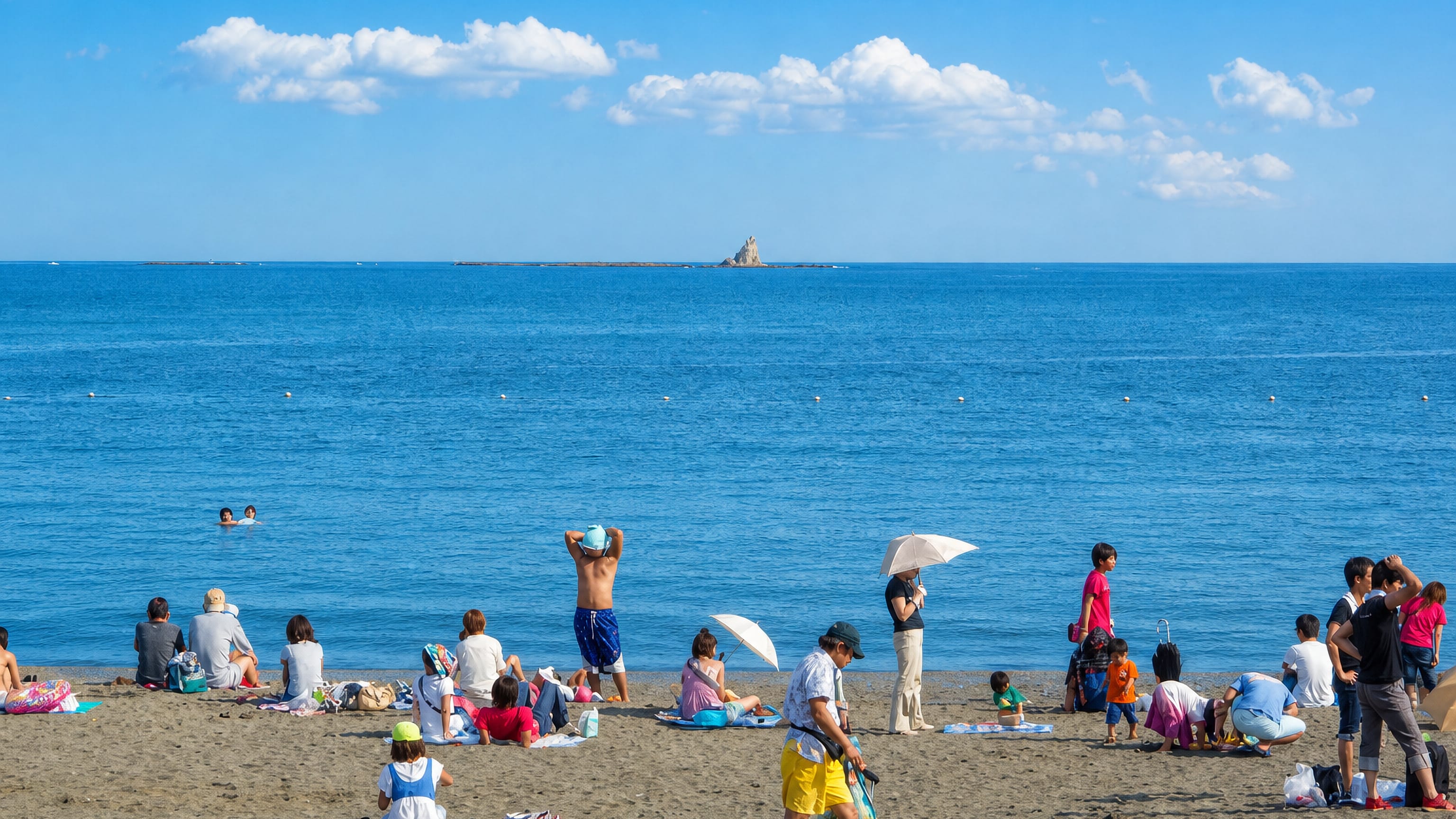 Bathers on Chigasaki's Southern Beach looking out to Eboshi Rock on the horizon of Sagami Bay.