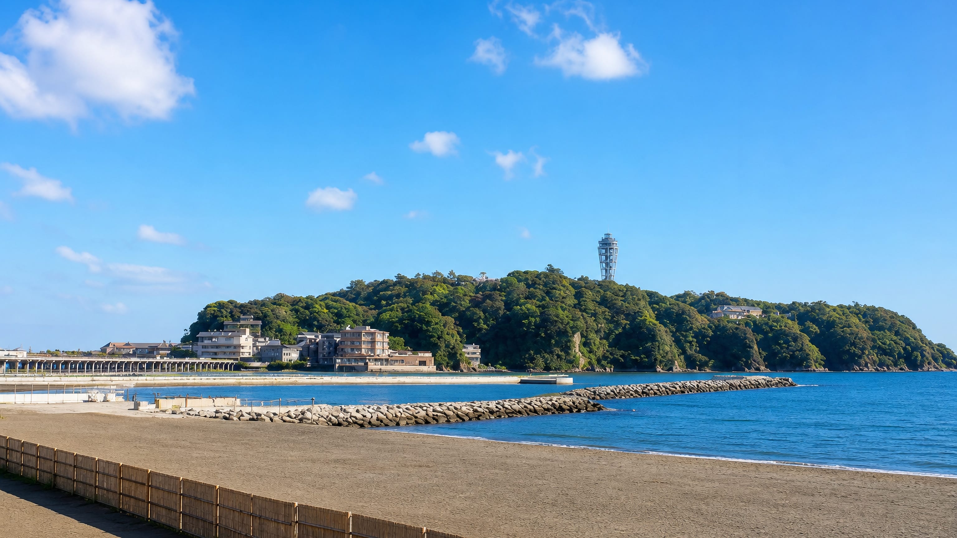 Enoshima island and its observation tower seen across Katase beach in Fujisawa, Japan.