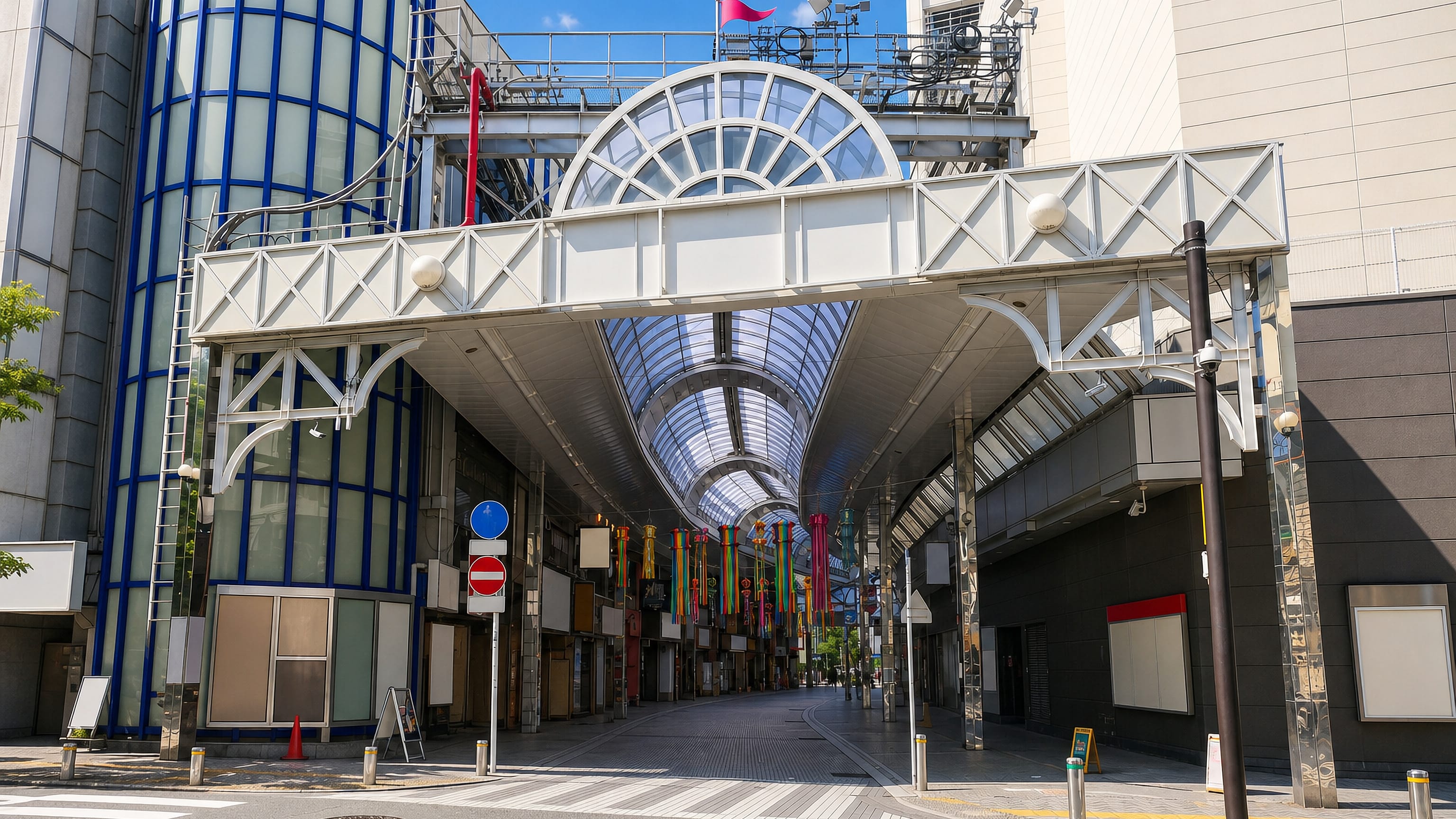 Glass-roofed shopping arcade entrance on a quiet street in the Isago district of Kawasaki, Japan.