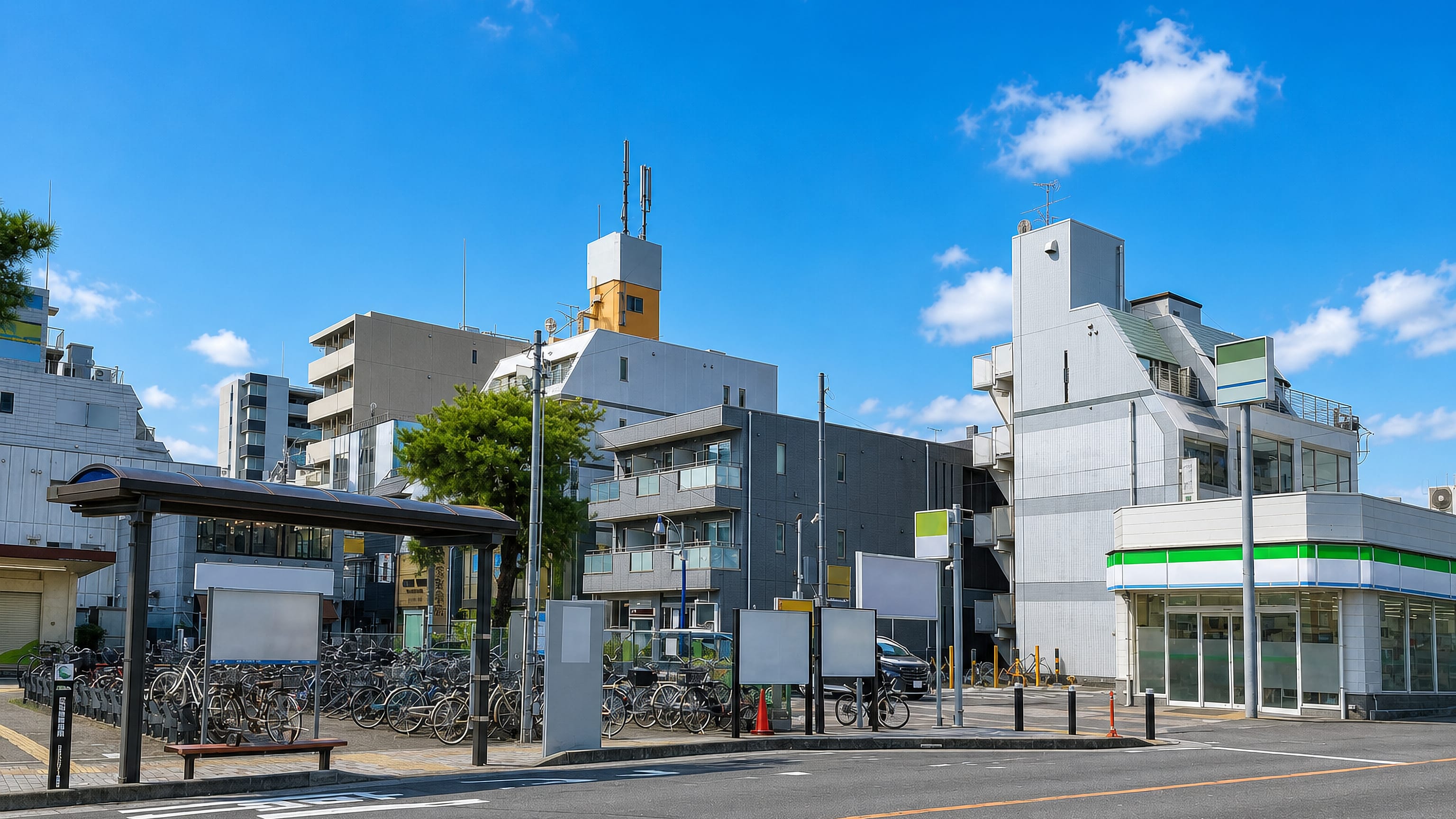 Low-rise apartment blocks, a convenience store and packed bicycle parking by a station in Yamato, Japan.