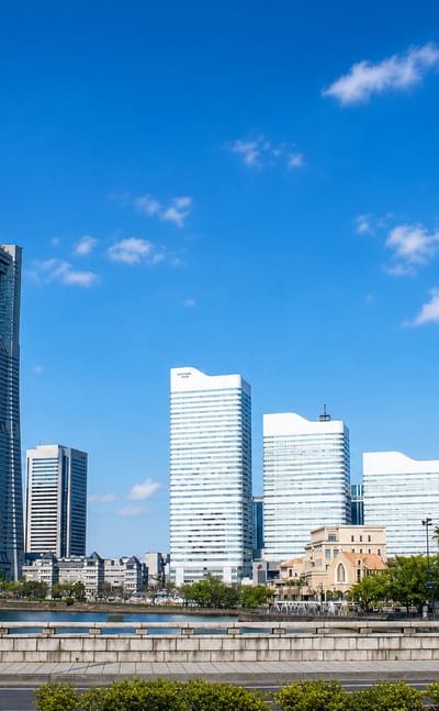 Yokohama Minato Mirai waterfront skyline with the Landmark Tower and Cosmo Clock 21 Ferris wheel under blue sky